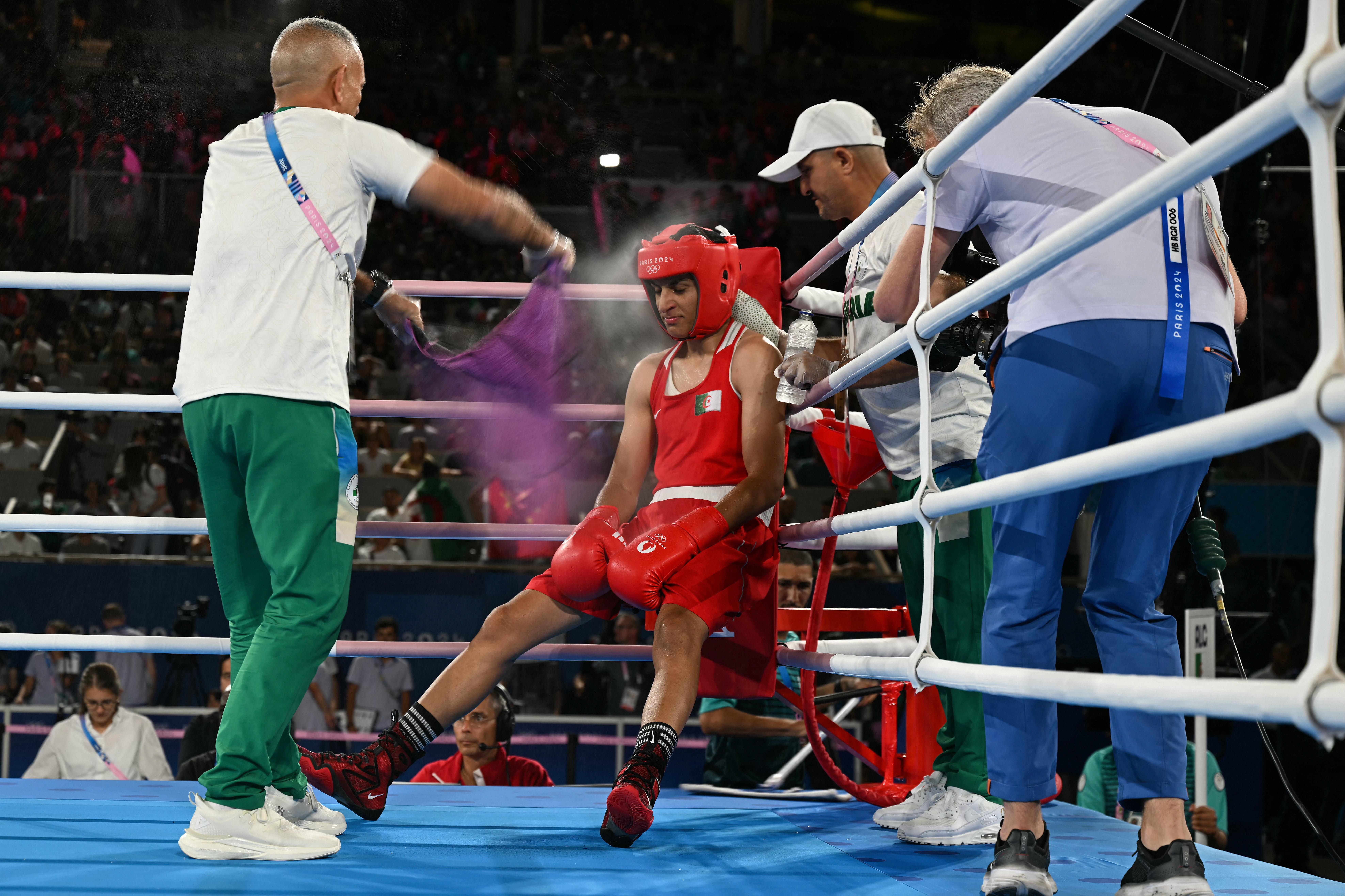 TOPSHOT - Algeria's Imane Khelif receives instructions from the coach during the break while competing against China's Yang Liu in the women's 66kg final boxing match during the Paris 2024 Olympic Games at the Roland-Garros Stadium, in Paris on August 9, 2024. (Photo by MOHD RASFAN / AFP)