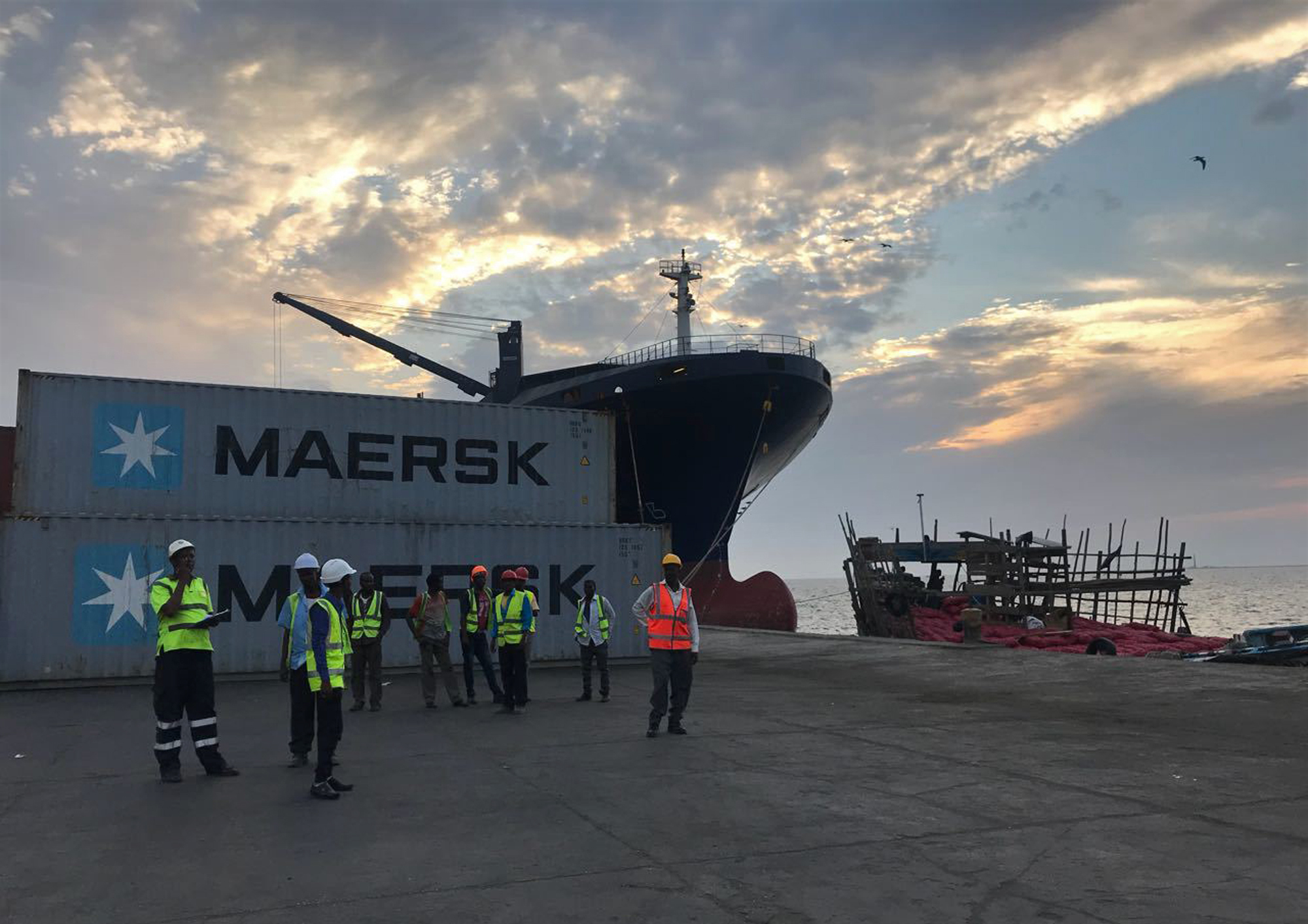 In this Sunday, April 1, 2018 photo, workers stand in front of shipping containers at the Port of Berbera, run by DP World, which is majority-owned by the Dubai government in the UAE, in Berbera, Somaliland, Somalia.