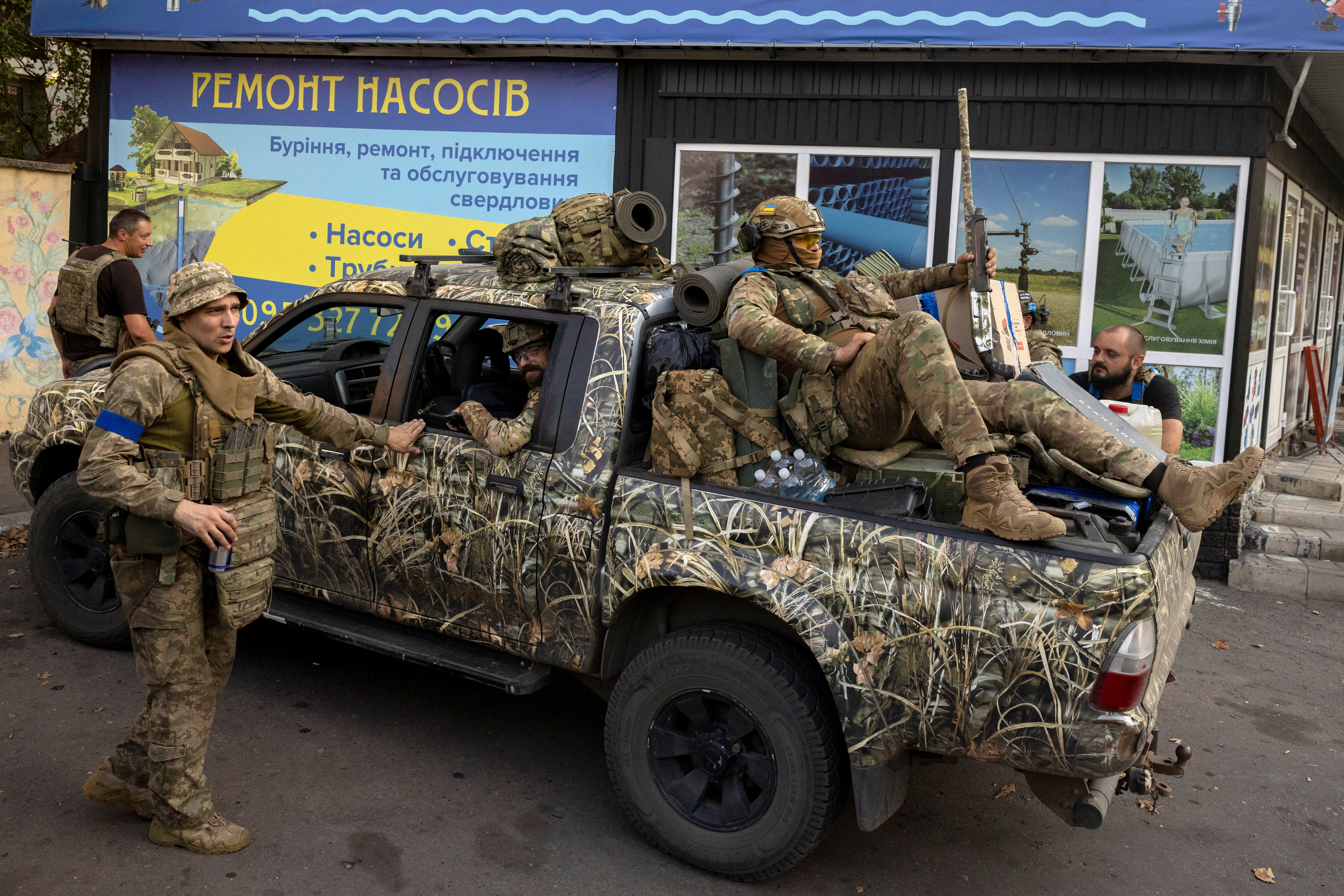 Ukrainian servicemen gather around a pickup truck in Pokrovsk, Ukraine, as they prepare to move into battle, amid Russia's attack on Ukraine, August 24, 2024. REUTERS/Thomas Peter