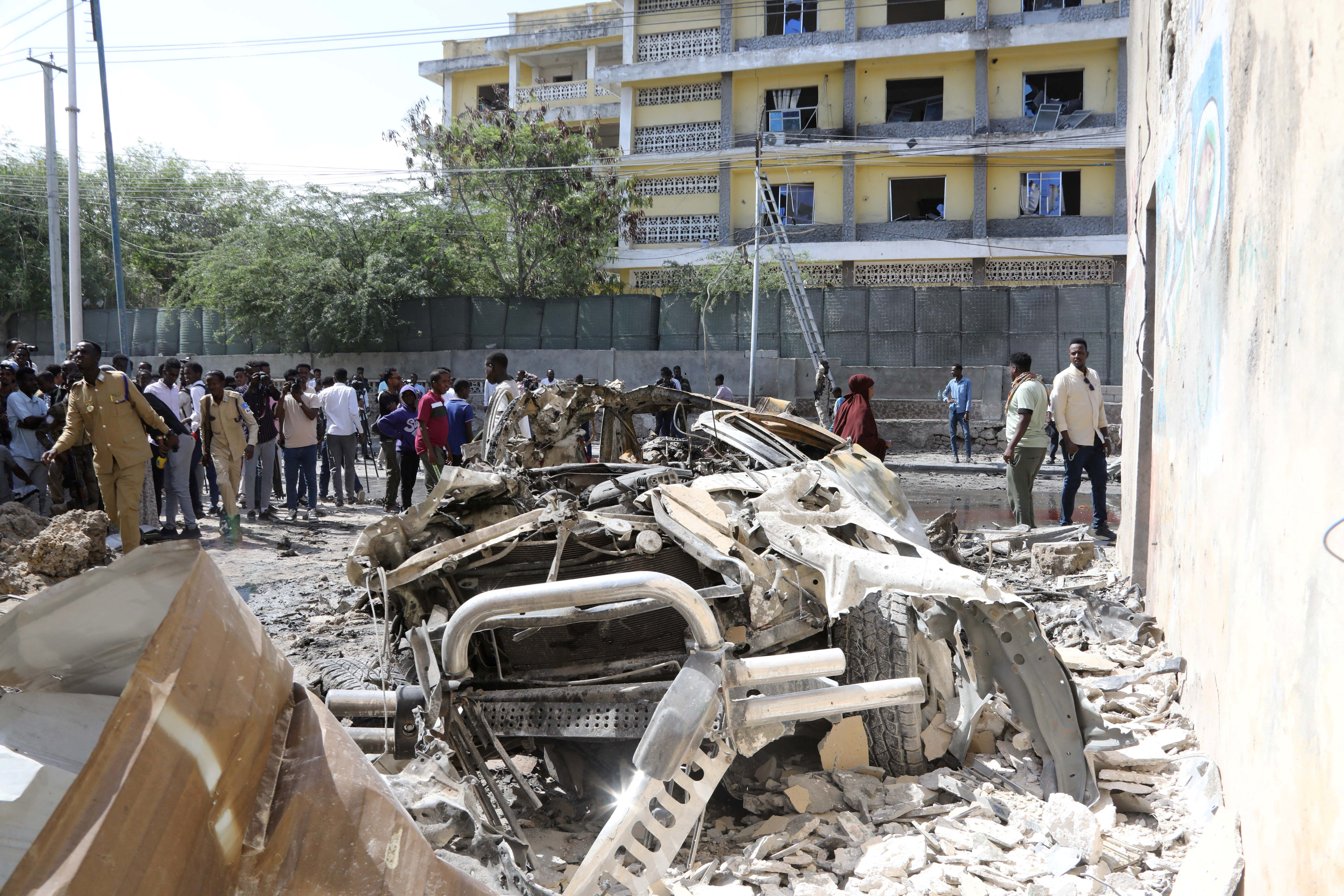 Somali security officers guard residents from the wreckage at the scene of an explosion of a bomb-rigged car that was parked on a road near the National Theatre in Hamarweyne district of Mogadishu, Somalia September 28, 2024. REUTERS/Feisal Omar