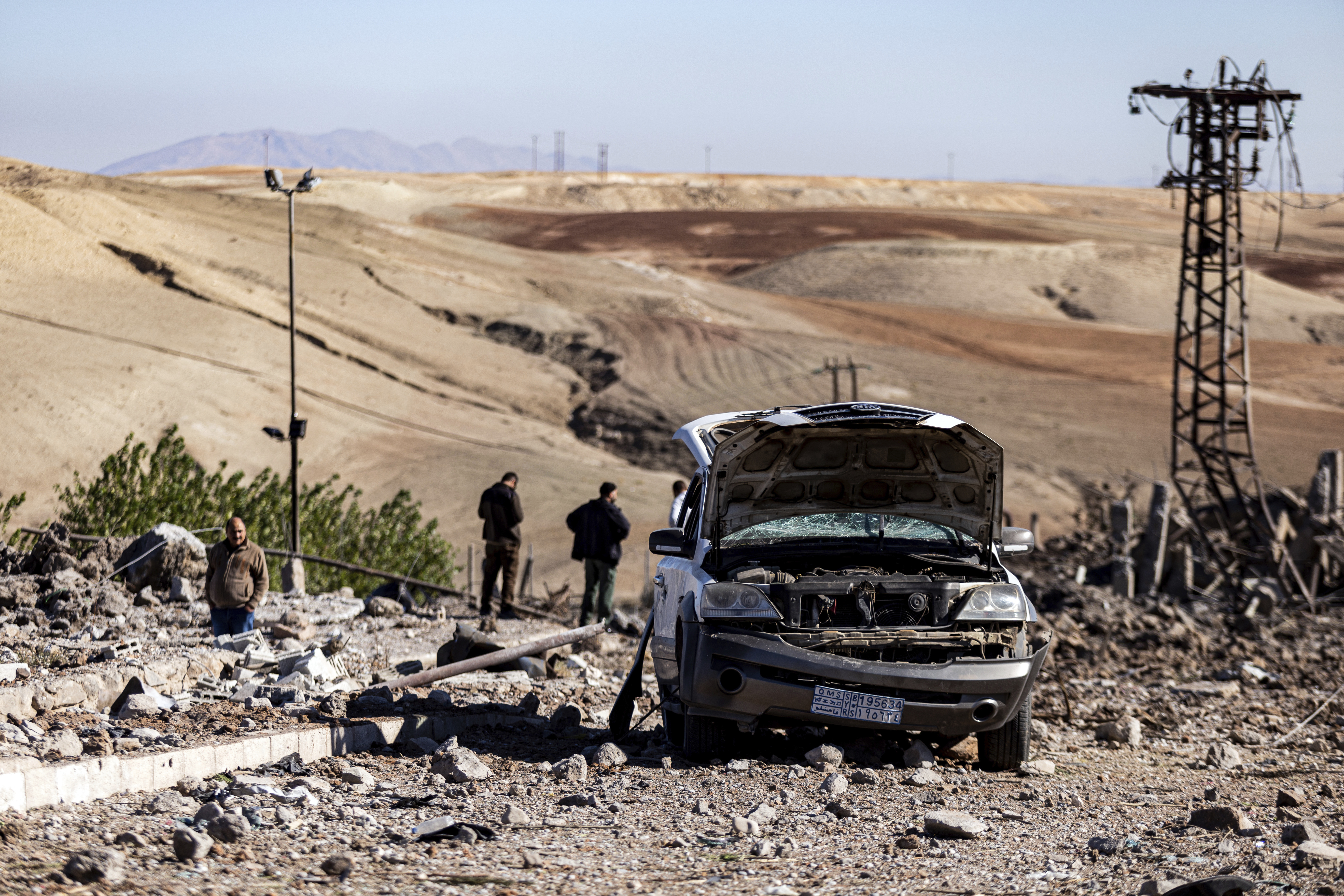 People inspect a site damaged by Turkish air strikes
