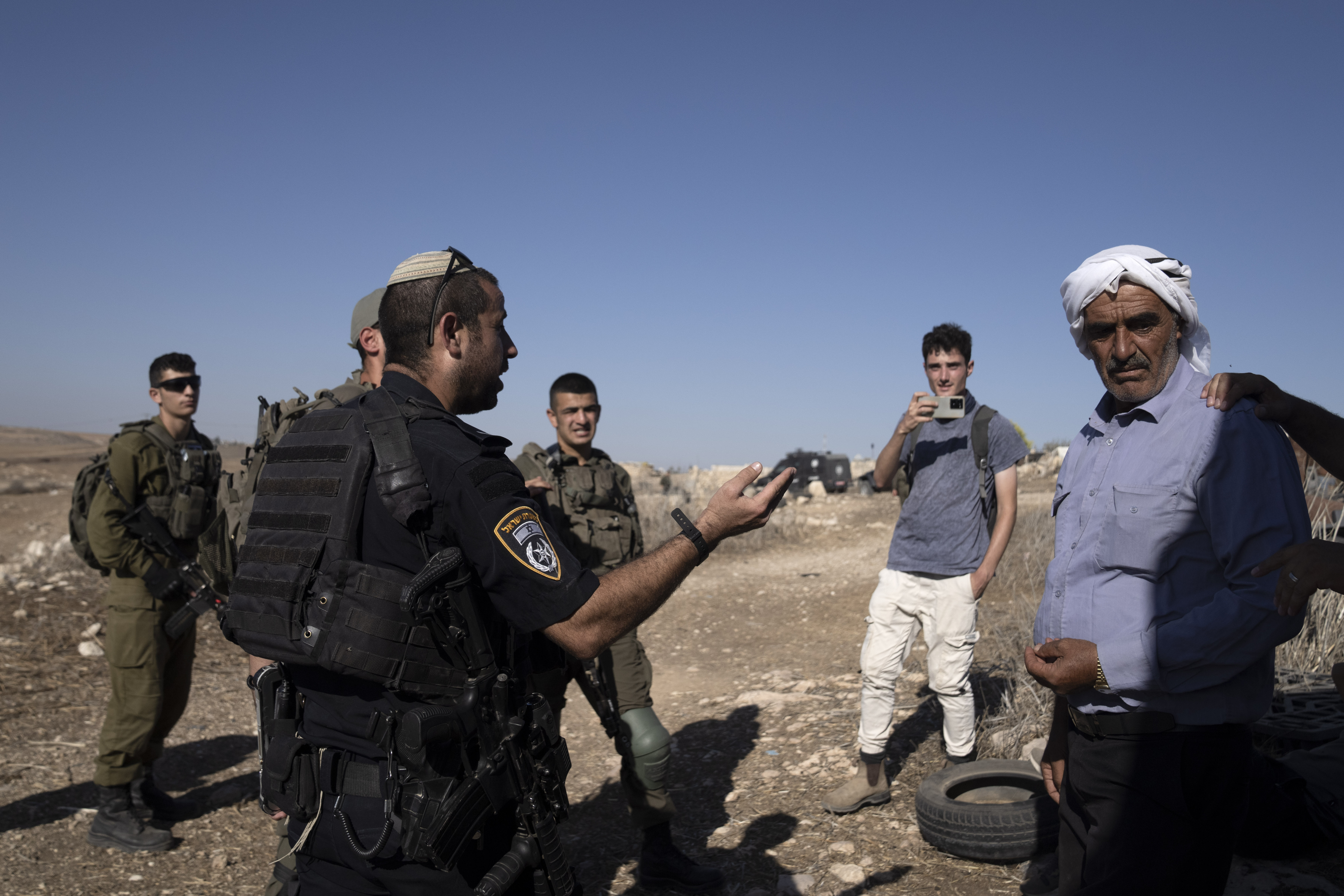 Israeli Police speak to residents of the West Bank village of Khirbet Zanuta, after activists called to report Israeli setters in the village,Thursday, Aug. 29