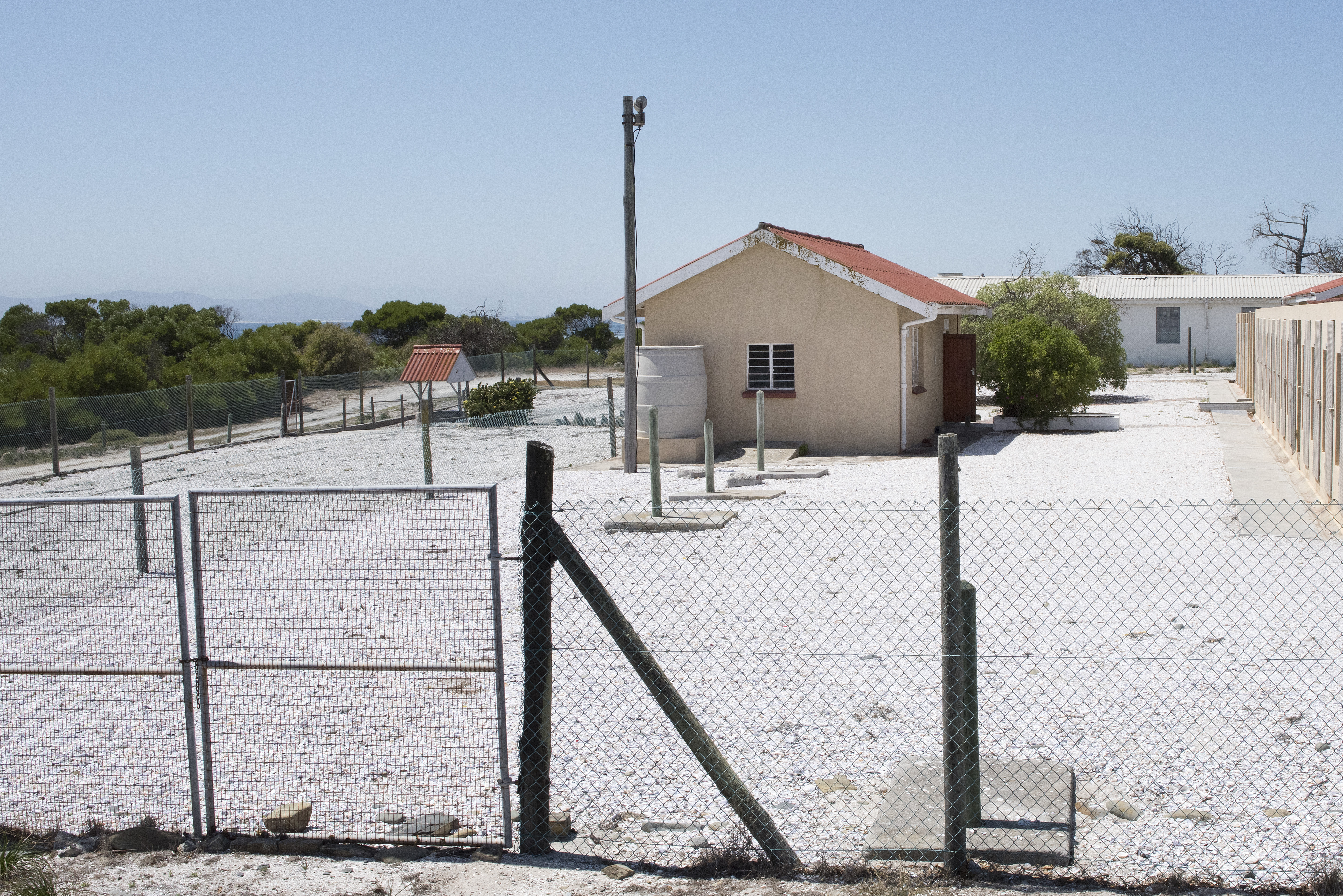 A view of the one-roomed prison building (L) where Robert Sobukwe, a Pan-Africanist Anti-Apartheid activist was kept in solitary confinement on Robben Island, where Nelson Mandela, an anti-apartheid revolutionary and the former president of South Africa, spent 18 of the 27 years he was imprisoned, on January 16, 2020. The Robben Island prison is now a museum dedicated to showing visitors the brutal conditions under which the prisoners lived, but also how important the island became as a base to counter the Apartheid regime. Nelson Mandela was released from prison after 27 years on February 11, 1990, and went to win the Nobel Peace prize and become the first President of democratic South Africa. (Photo by RODGER BOSCH / AFP)
