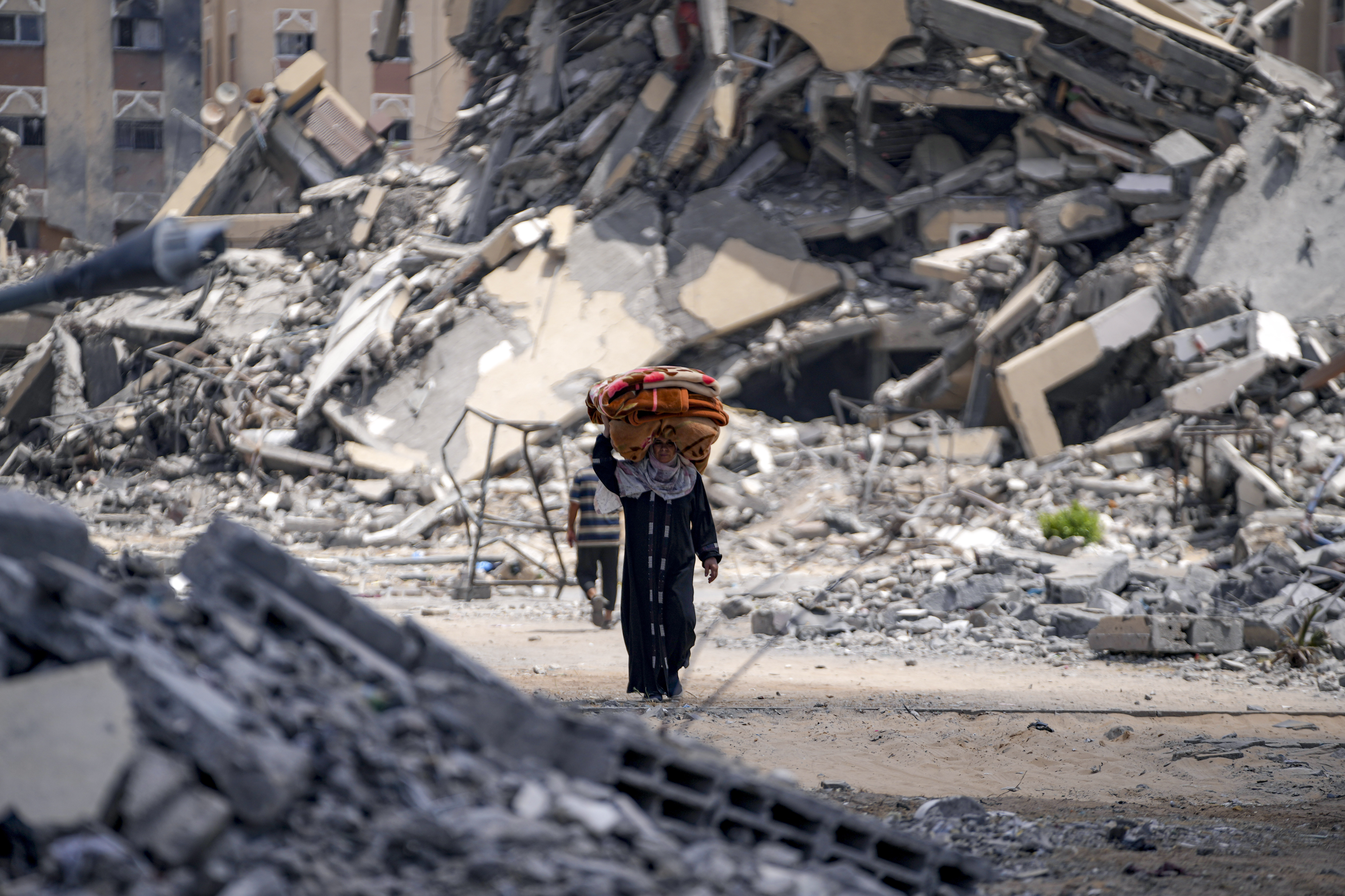 A Palestinian displaced woman by the Israeli air and ground offensive on the Gaza Strip flees from Hamad City, following an evacuation order by the Israeli army to leave parts of the southern area of Khan Younis, Sunday, Aug. 11, 2024. (AP Photo/Abdel Kareem Hana)