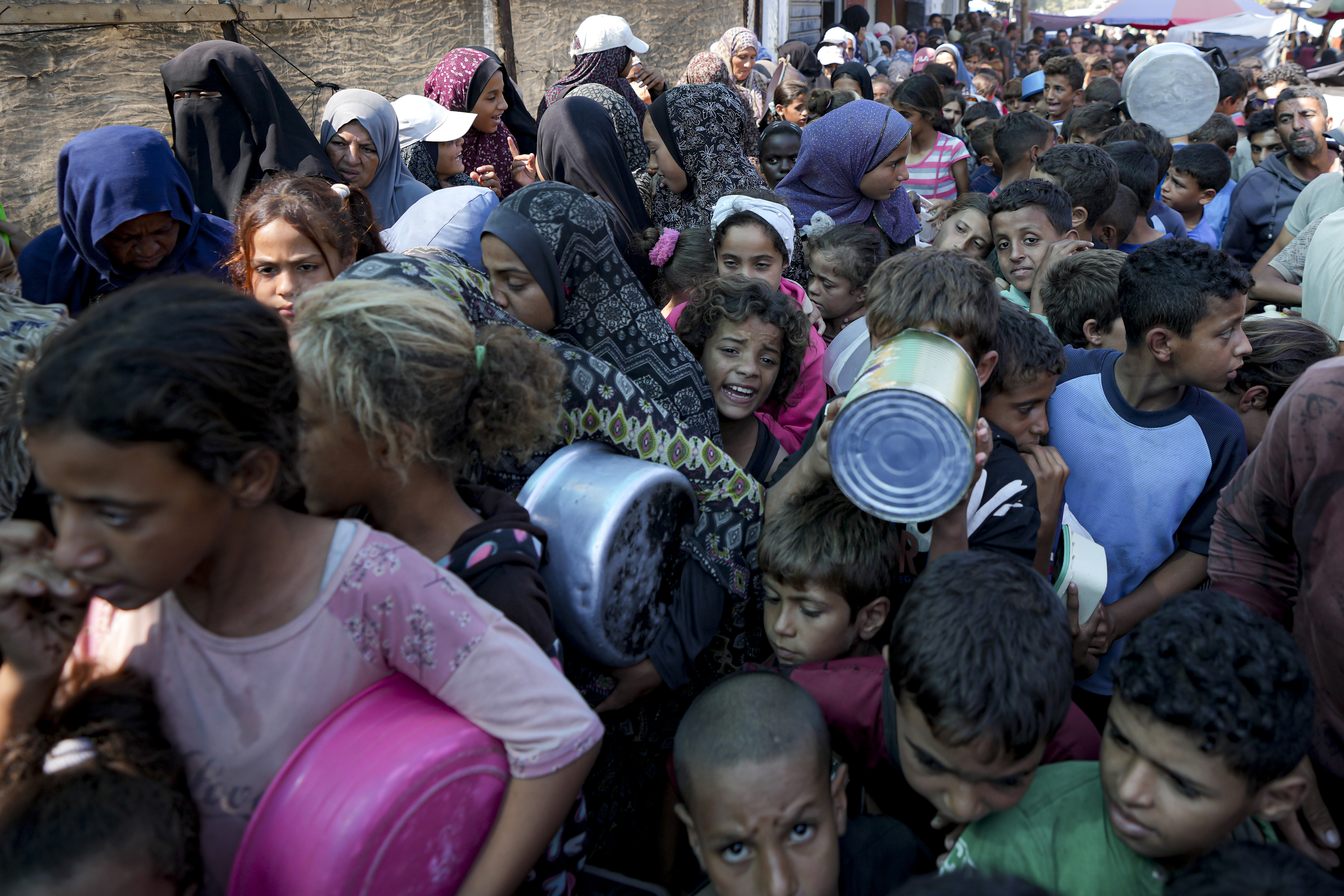 Palestinians line up for food distribution in Deir el-Balah, Gaza