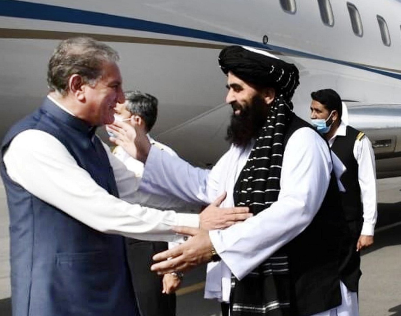 Pakistani Foreign Minister Shah Mahmood Qureshi greets with acting Foreign Minister of the Interim Afghan government of Taliban Amir Khan Muttqi, upon his arrival in Kabul, Afghanistan October 21, 2021. Press Information Department (PID) Handout via REUTERS/ATTENTION EDITORS - THIS PICTURE WAS PROVIDED BY A THIRD PARTY.