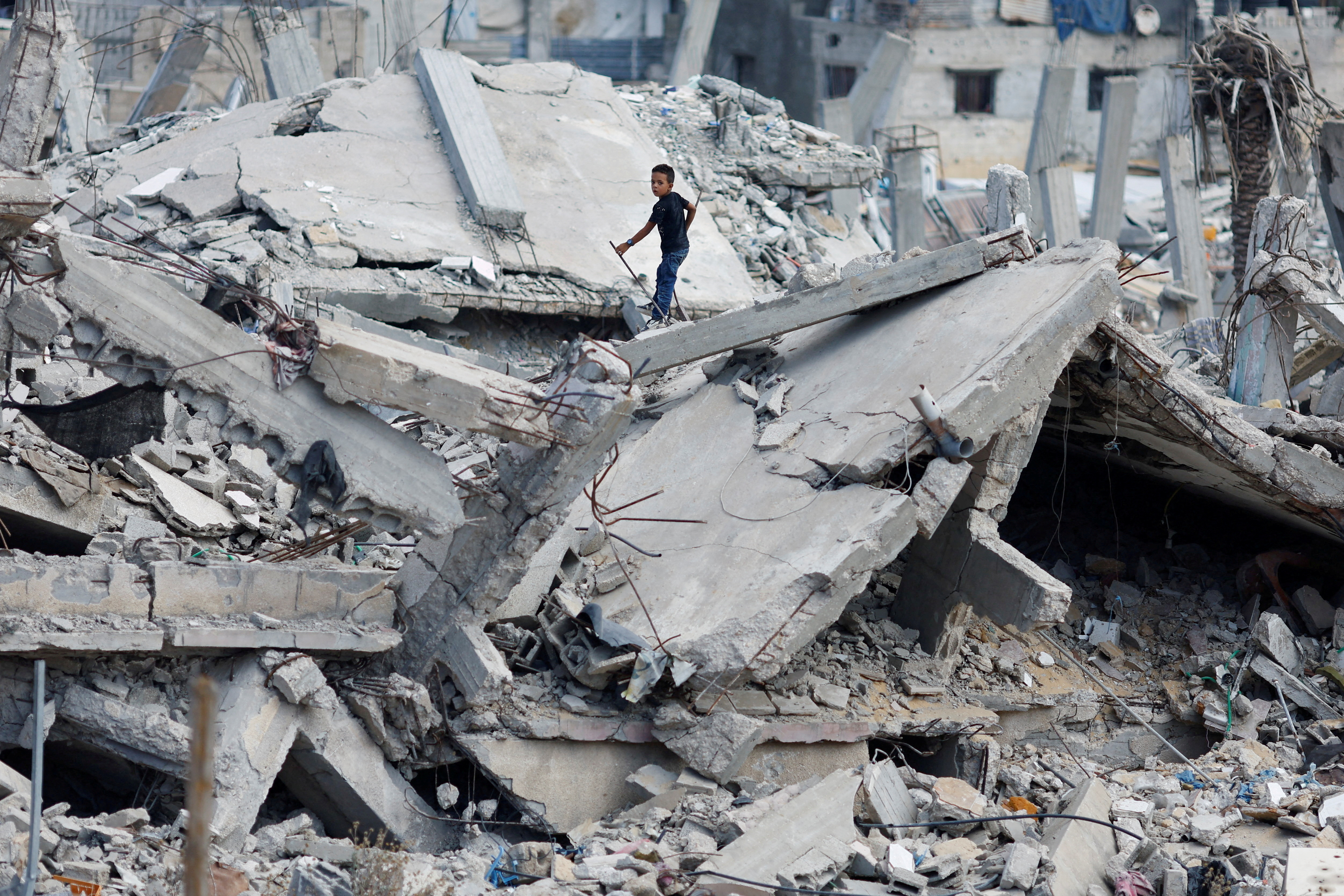 FILE PHOTO: A Palestinian boy stands on the rubble of a house destroyed in Israel's military offensive, amid the ongoing conflict between Israel and Hamas, in Khan Younis in the southern Gaza Strip October 7, 2024. REUTERS/Mohammed Salem/File Photo