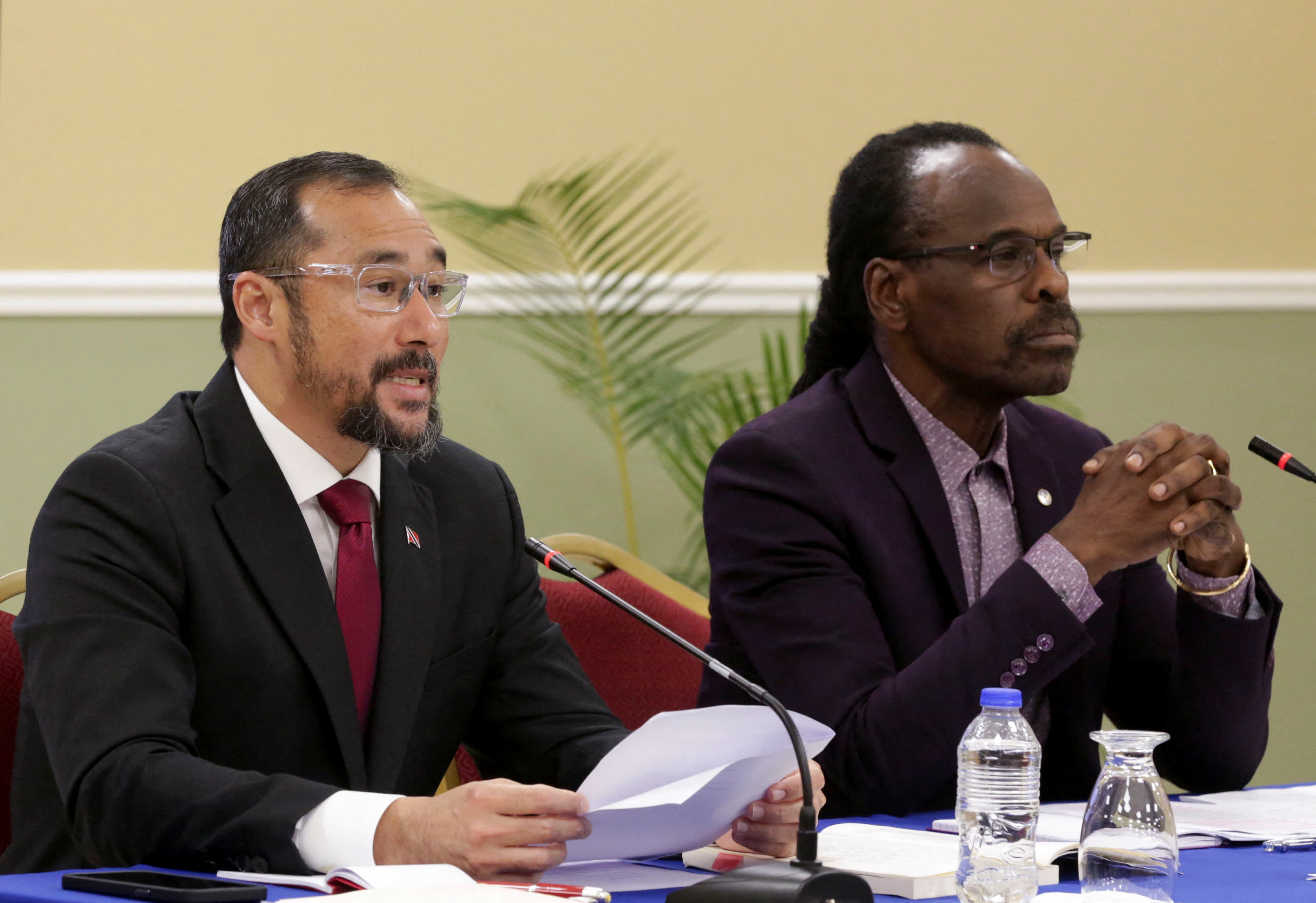 Stuart Young and Fitzgerald Hinds sit behind a table together at a news conference.