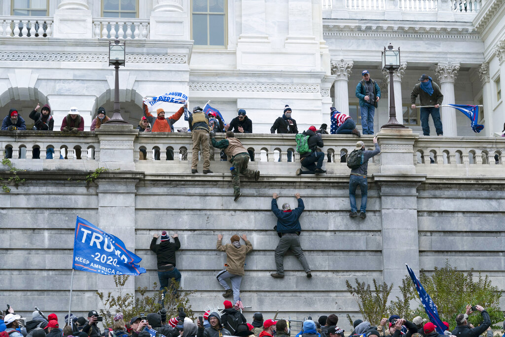 Trump supporters scale the wall of the US Capitol