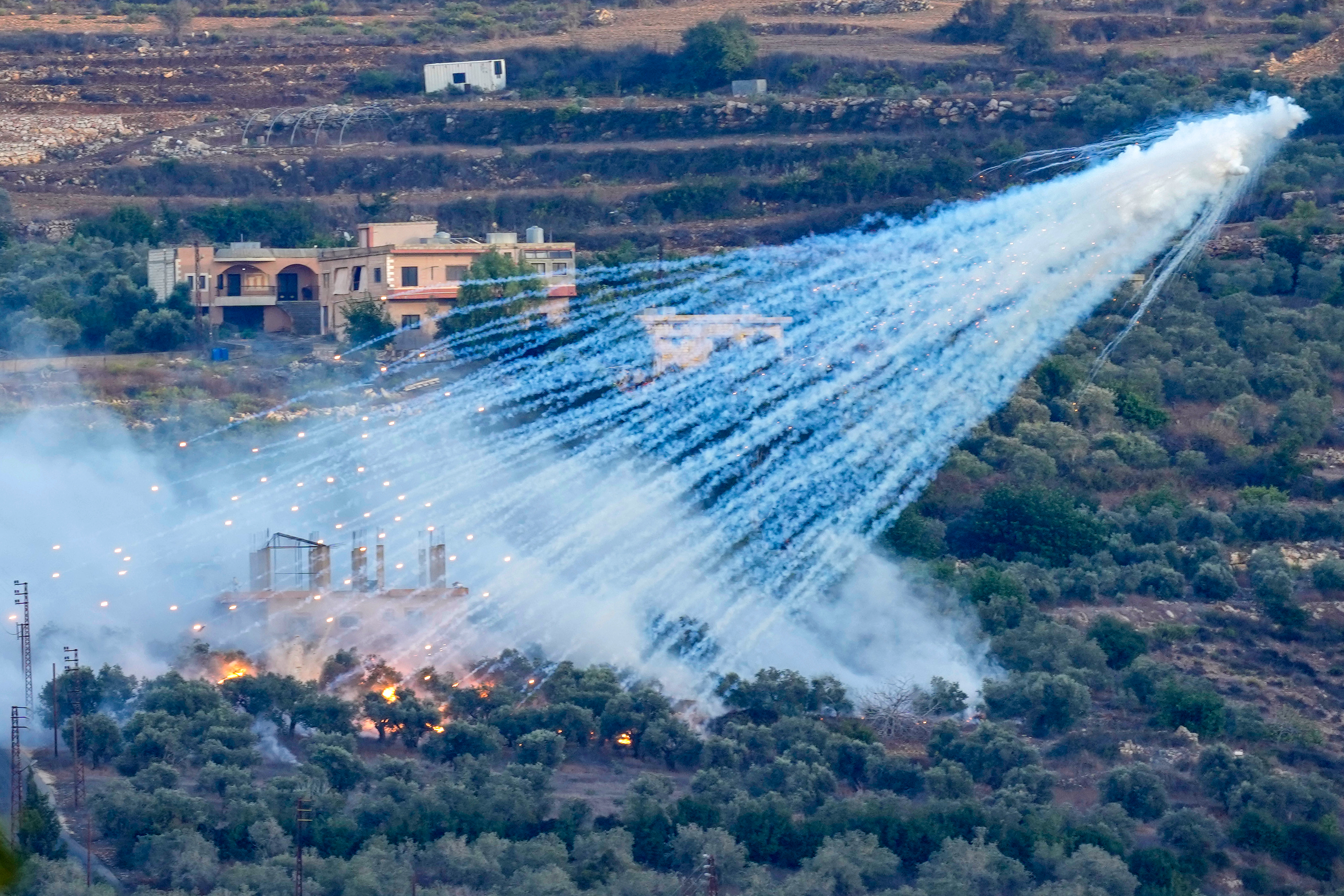 A shell that appears to be white phosphorus from Israeli artillery explodes
