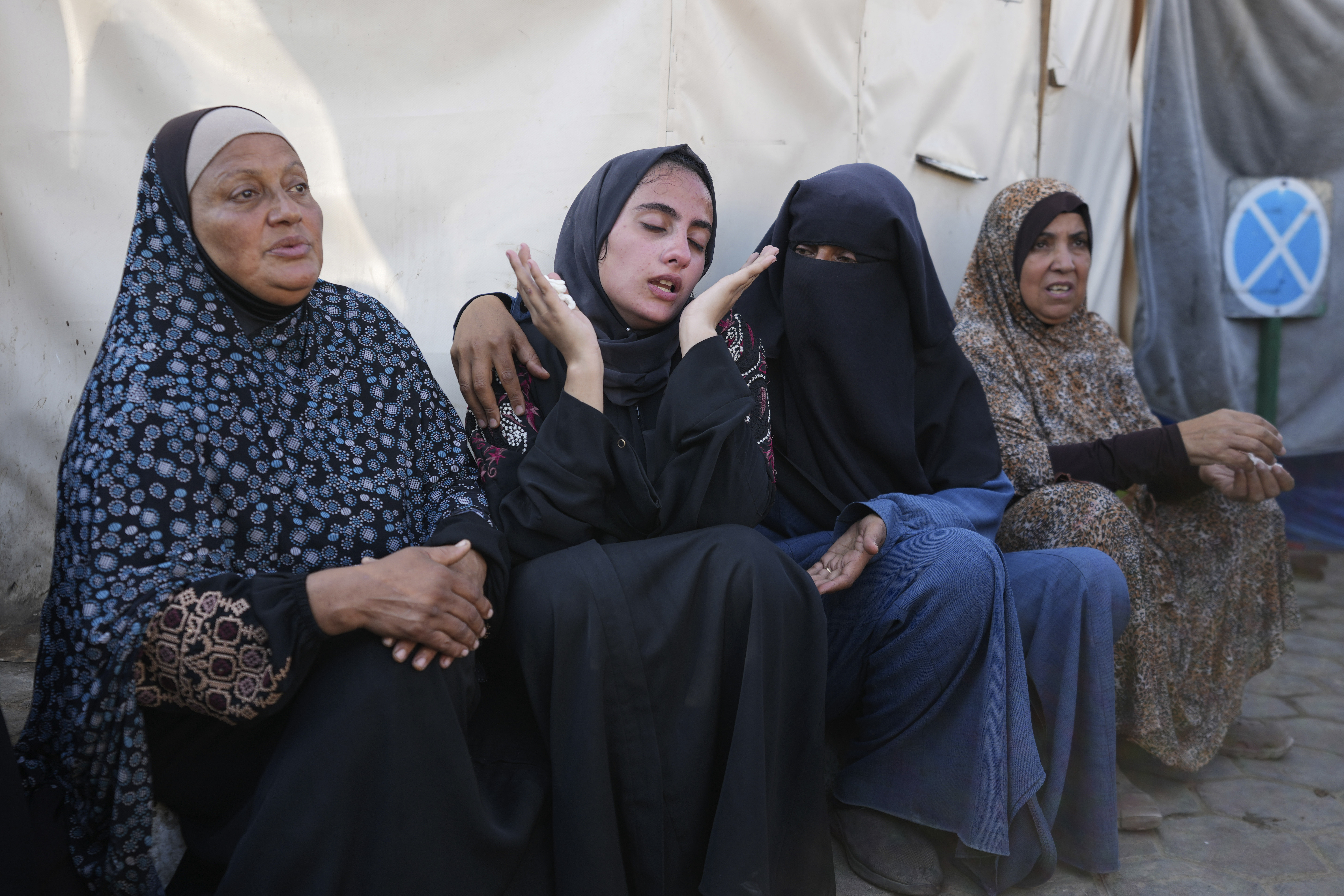 Palestinian women comfort each other at a funeral