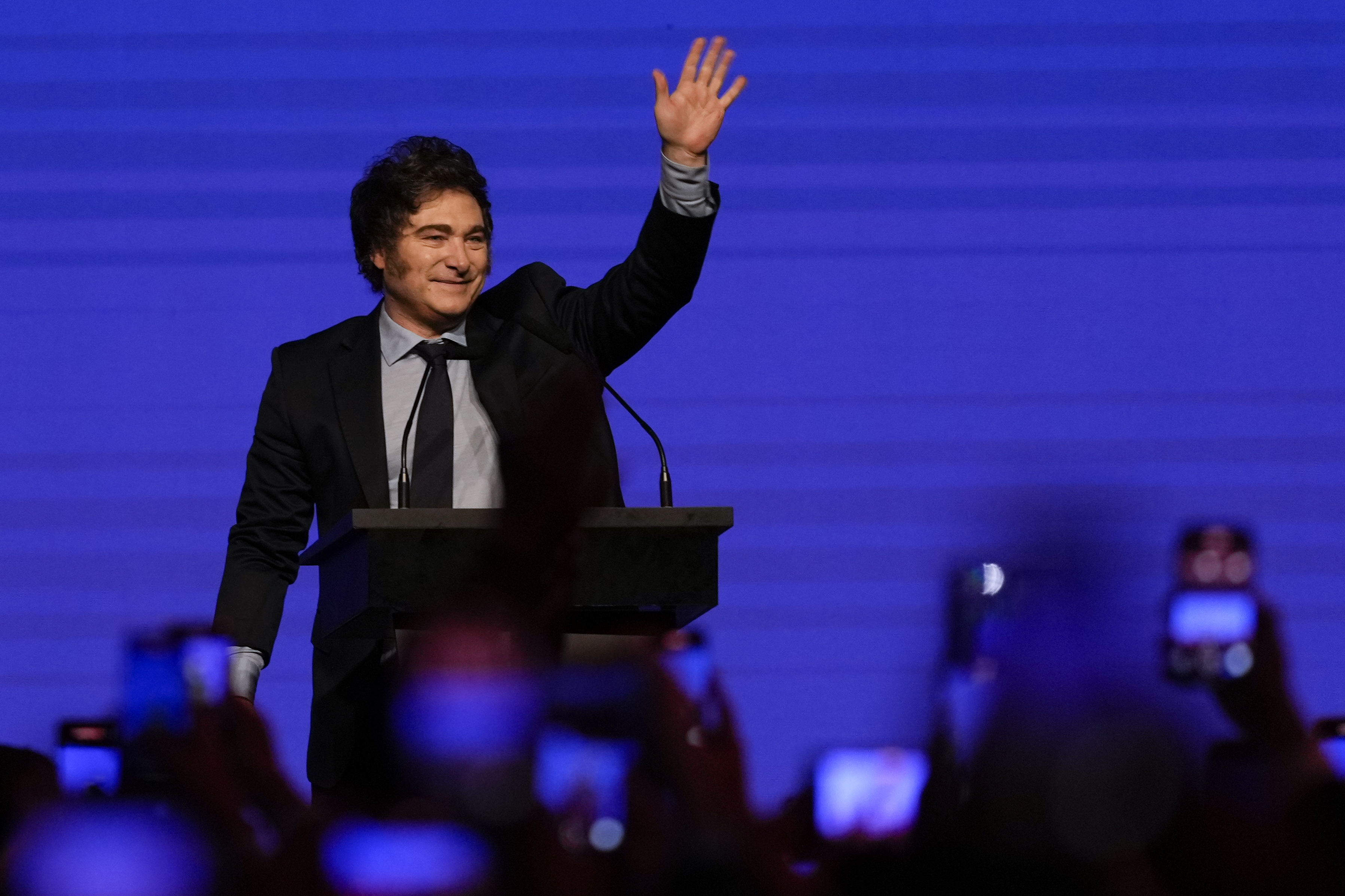 Javier Milei waves from the stage at CPAC Argentina