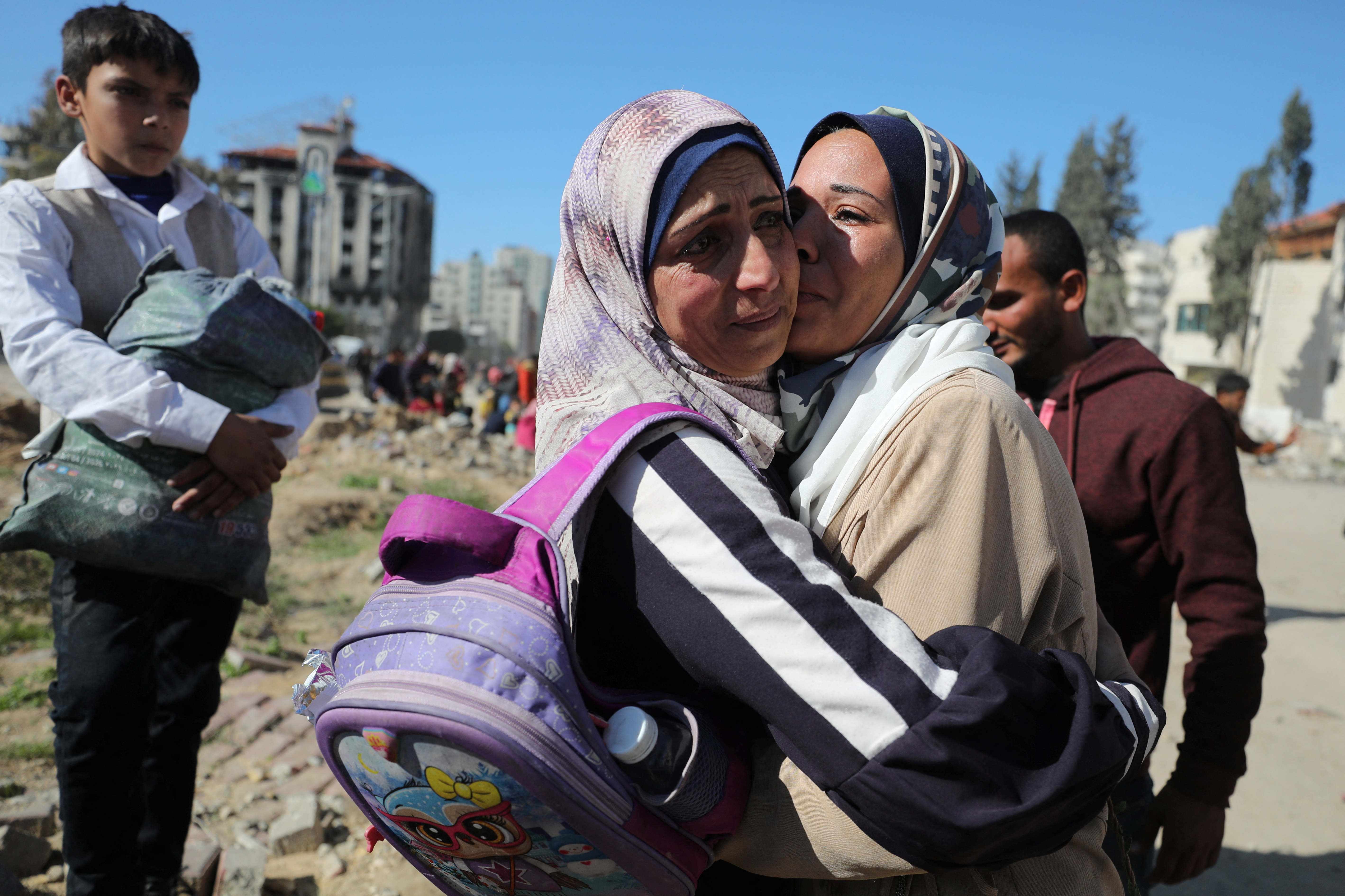 People hug each other as Palestinians, who were displaced to the south at Israel's order during the war, return to their homes in the northern Gaza, amid a ceasefire between Israel and Hamas, in Gaza City, January 27, 2025. REUTERS/Dawoud Abu Alkas