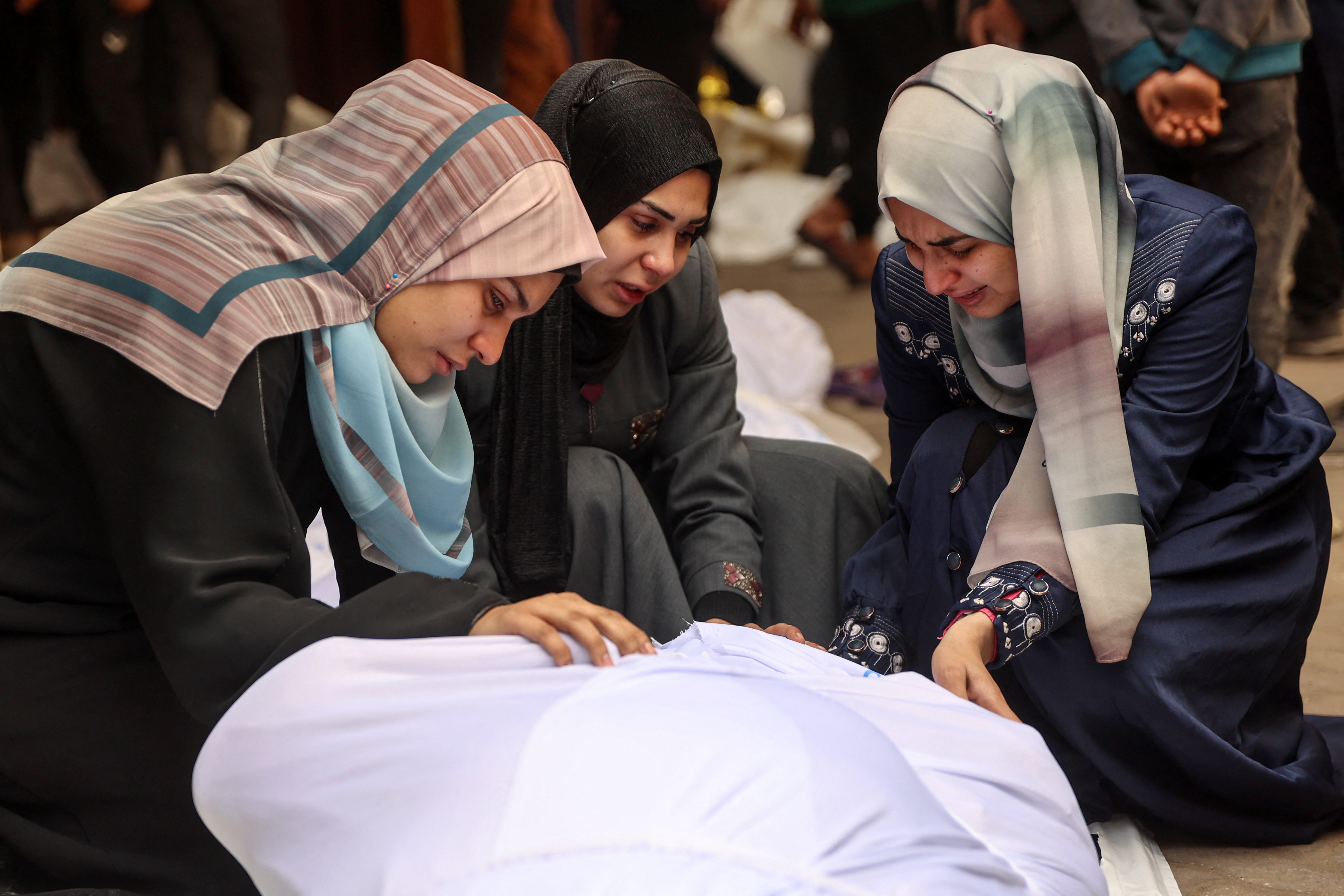 Women cry over the body of a loved one killed in Israeli strikes in Gaza City