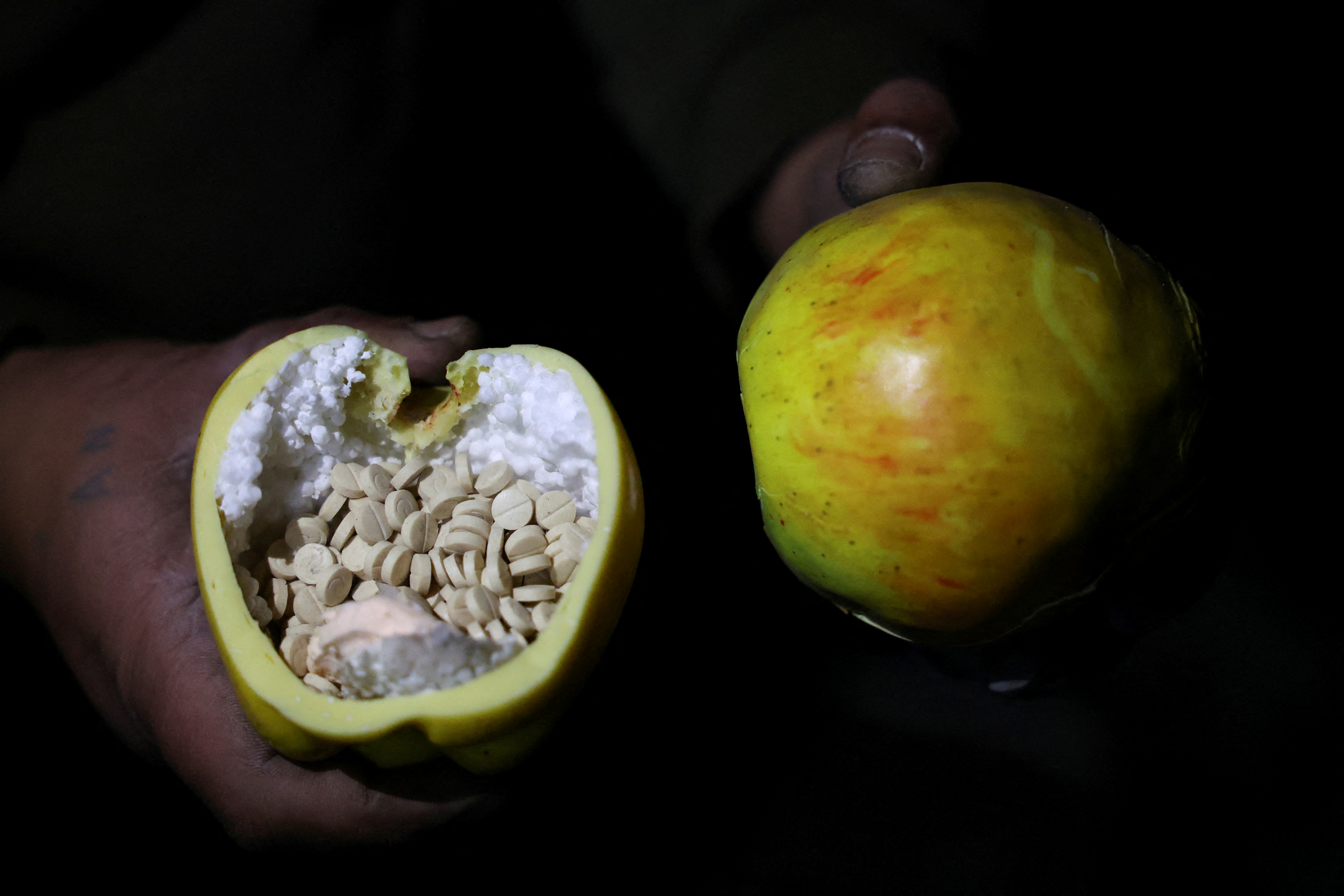 According to fighters loyal to Syria's new ruling government, pills believed to be Captagon are found inside an apple-shaped container, on the outskirts of Damascus, Syria, on December 12, 2024 [Mohamed Azakir/Reuters]