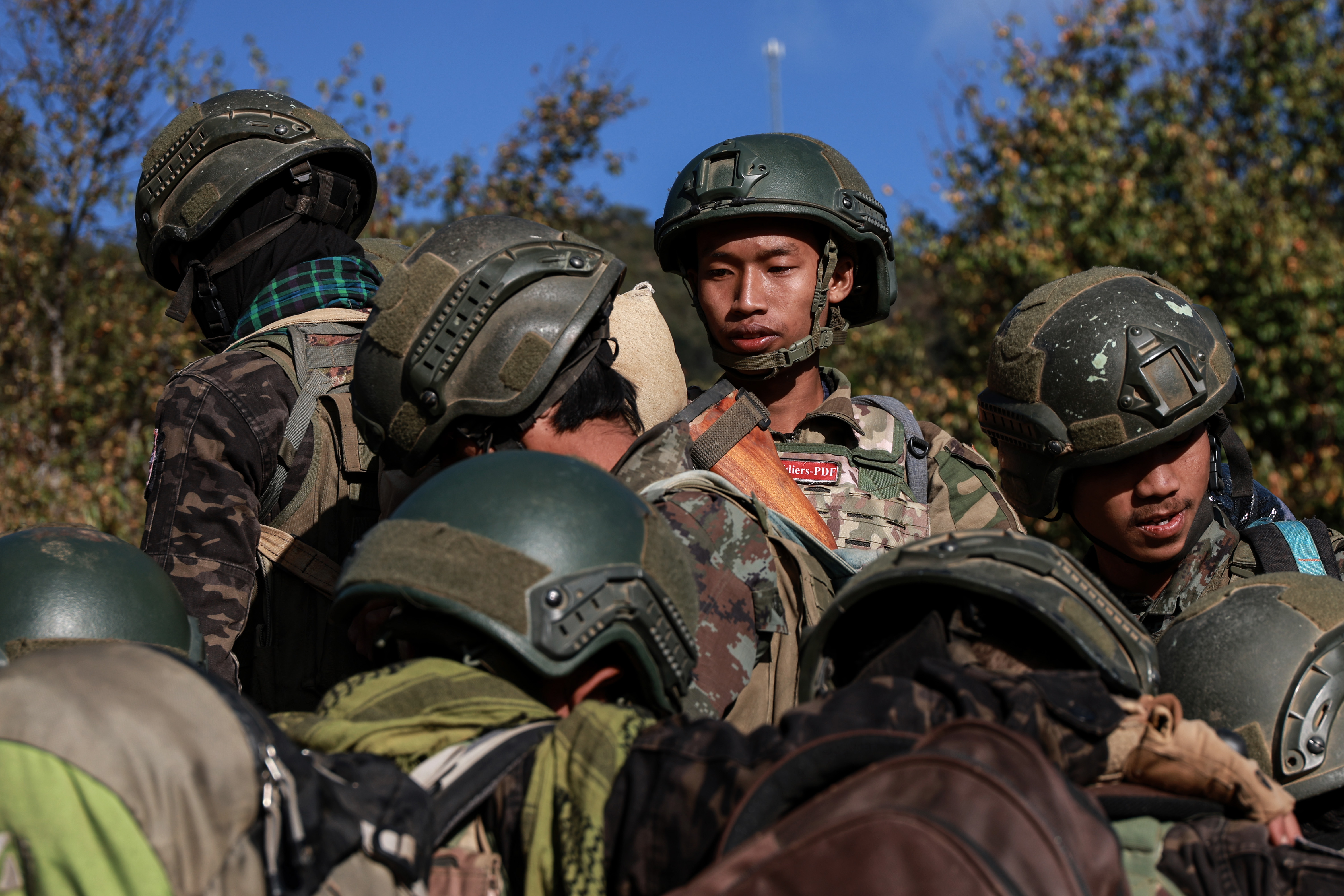 Resistance reinforcements sit on the back of a pickup truck as they leave to the frontline in Falam township, Chin State, Myanmar, in January 2025 [Valeria Mongelli/Al Jazeera]