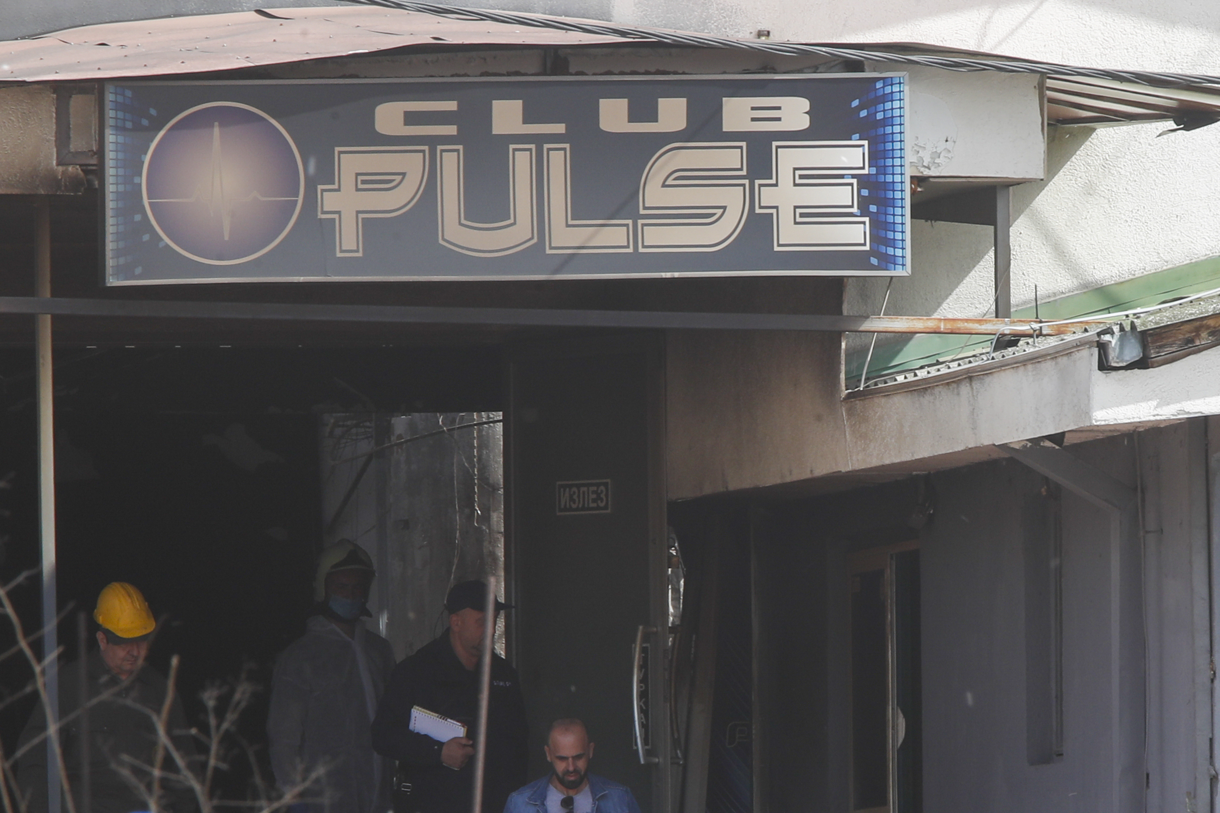 Police officers investigate a nightclub after a huge fire.