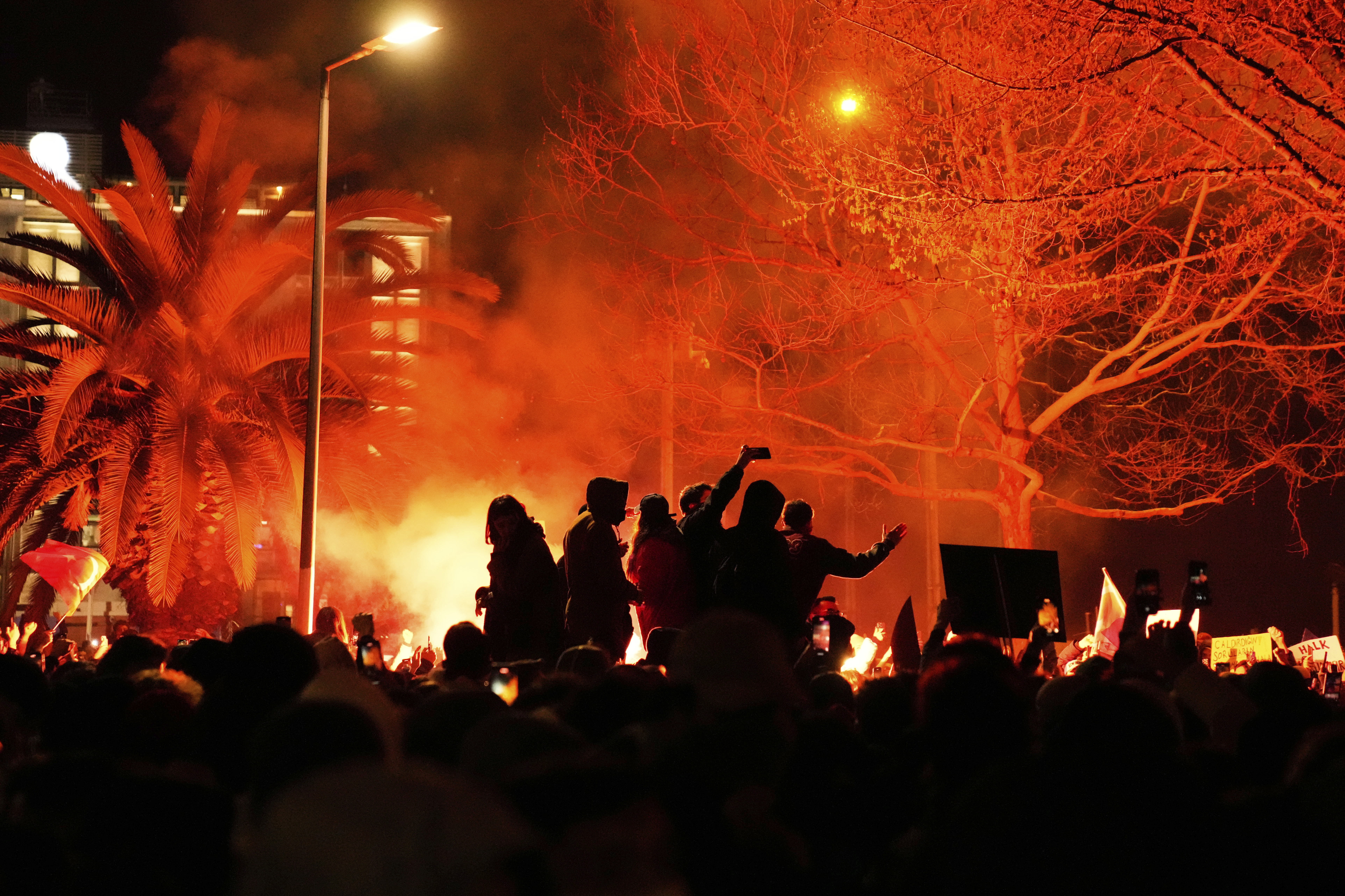 People light flares in Istanbul, Turkey, Thursday, March 20, 2025, as they protest against the arrest of Istanbul's Mayor Ekrem Imamoglu. (AP Photo/Khalil Hamra)
