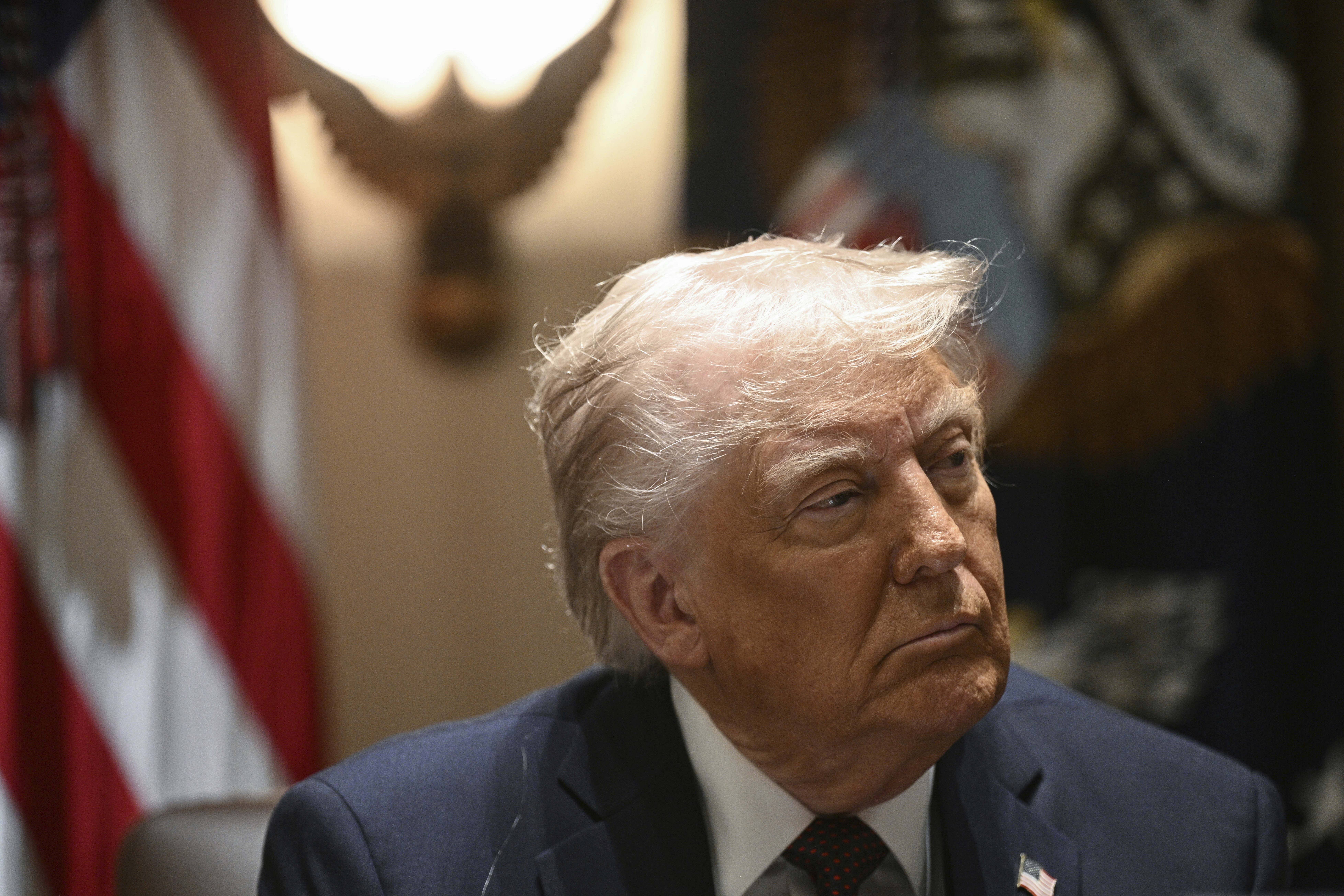Donald Trump seated at a cabinet meeting