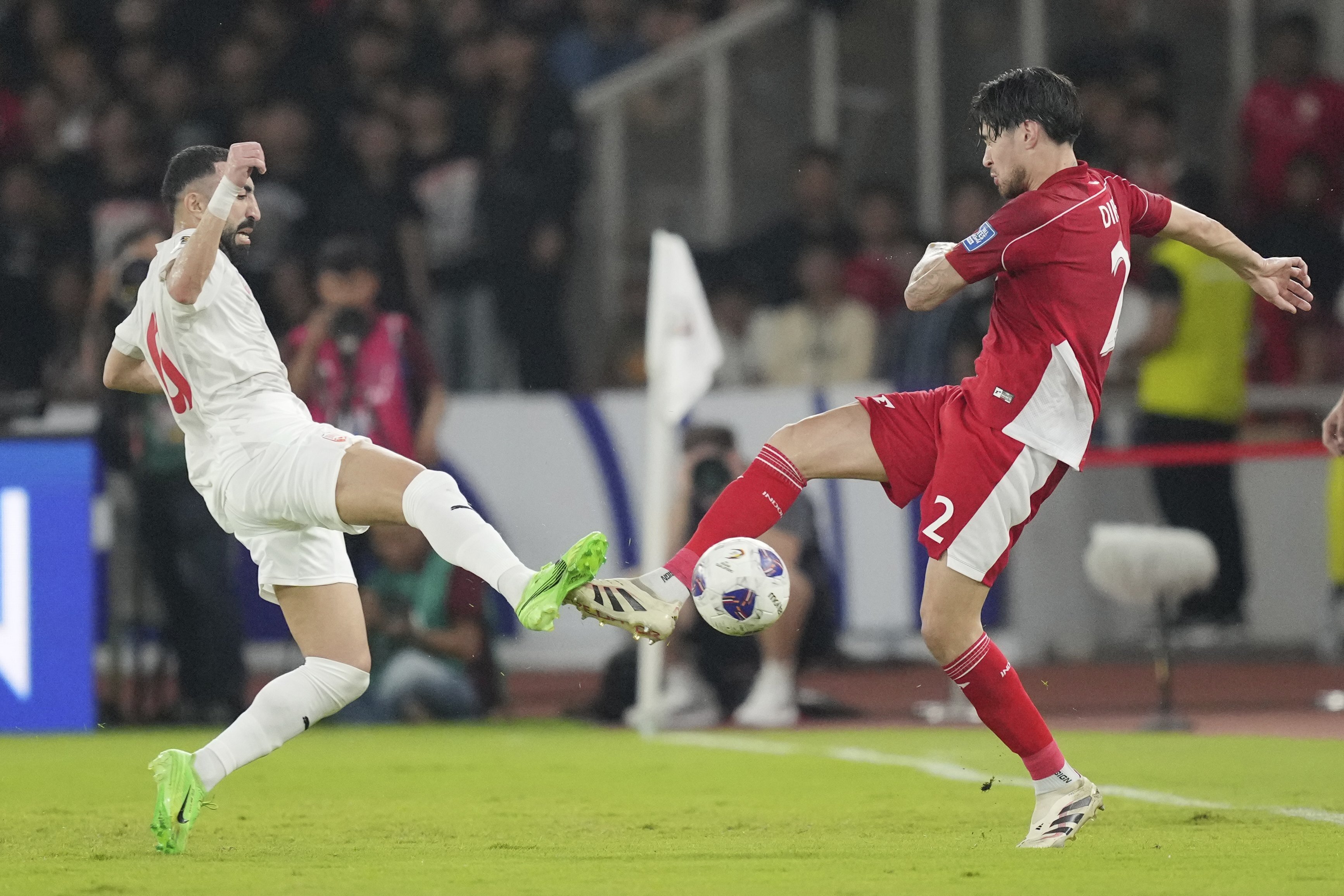 Indonesia's Kevin Diks, right, battles for the ball against Bahrain's Mahdi Humaidan during the third round of the 2026 World Cup Group C Asia qualifier soccer match between Indonesia and Bahrain at Gelora Bung Karno Main Stadium in Jakarta, Indonesia, Tuesday, March 25, 2025. (AP Photo/Tatan Syuflana)