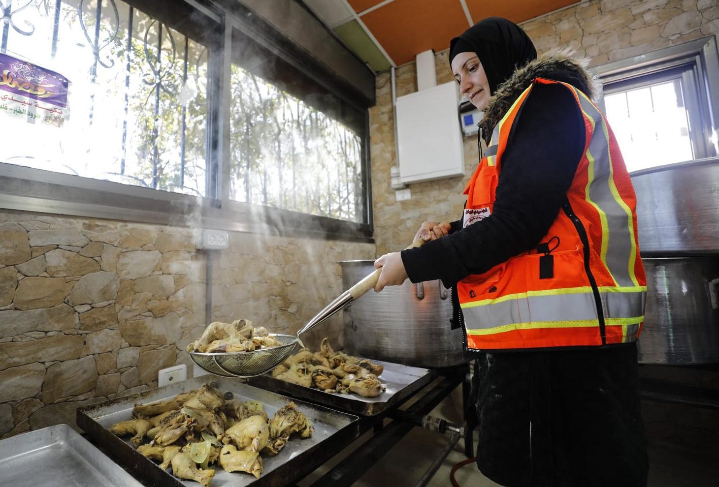 A volunteer prepares chicken for the 'table of mercy' iftar in el-Bireh