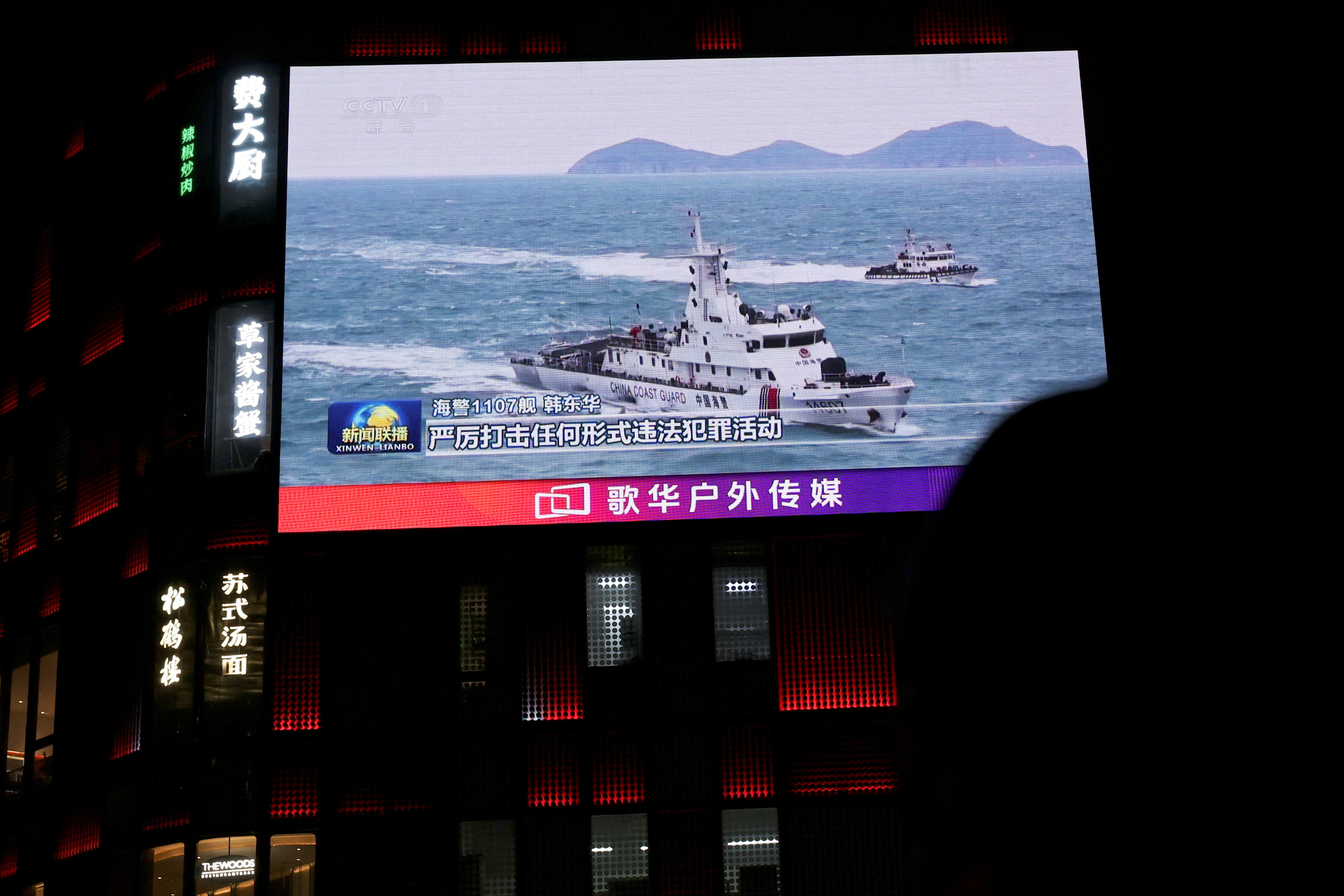 A China Coast Guard vessel is seen on a giant screen showing news footage about the coast guard's law enforcement patrols in waters around Taiwan, outside a shopping mall in Beijing, China, April 1, 2025. REUTERS/Florence Lo