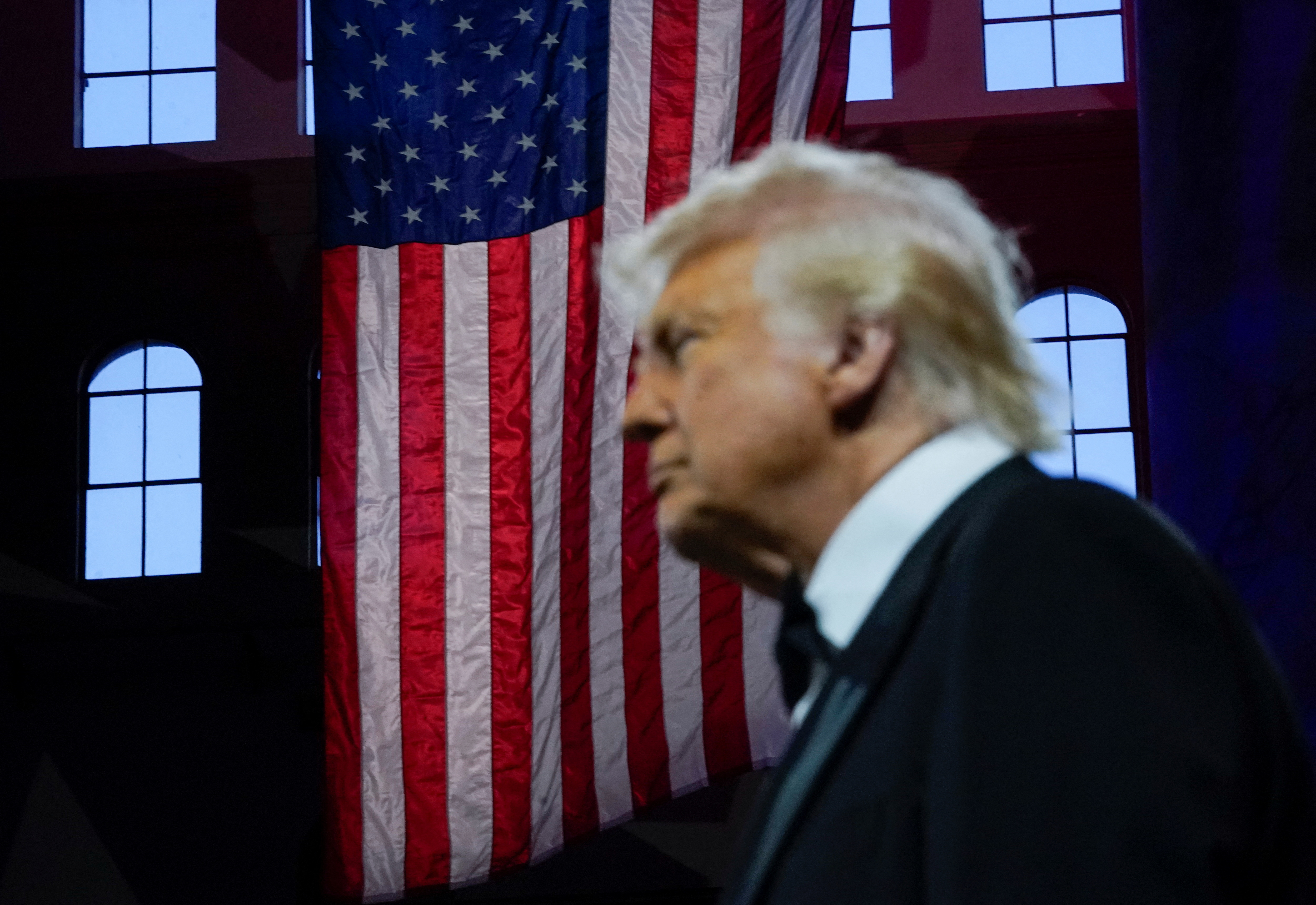 Trump with a United States flag behind him.