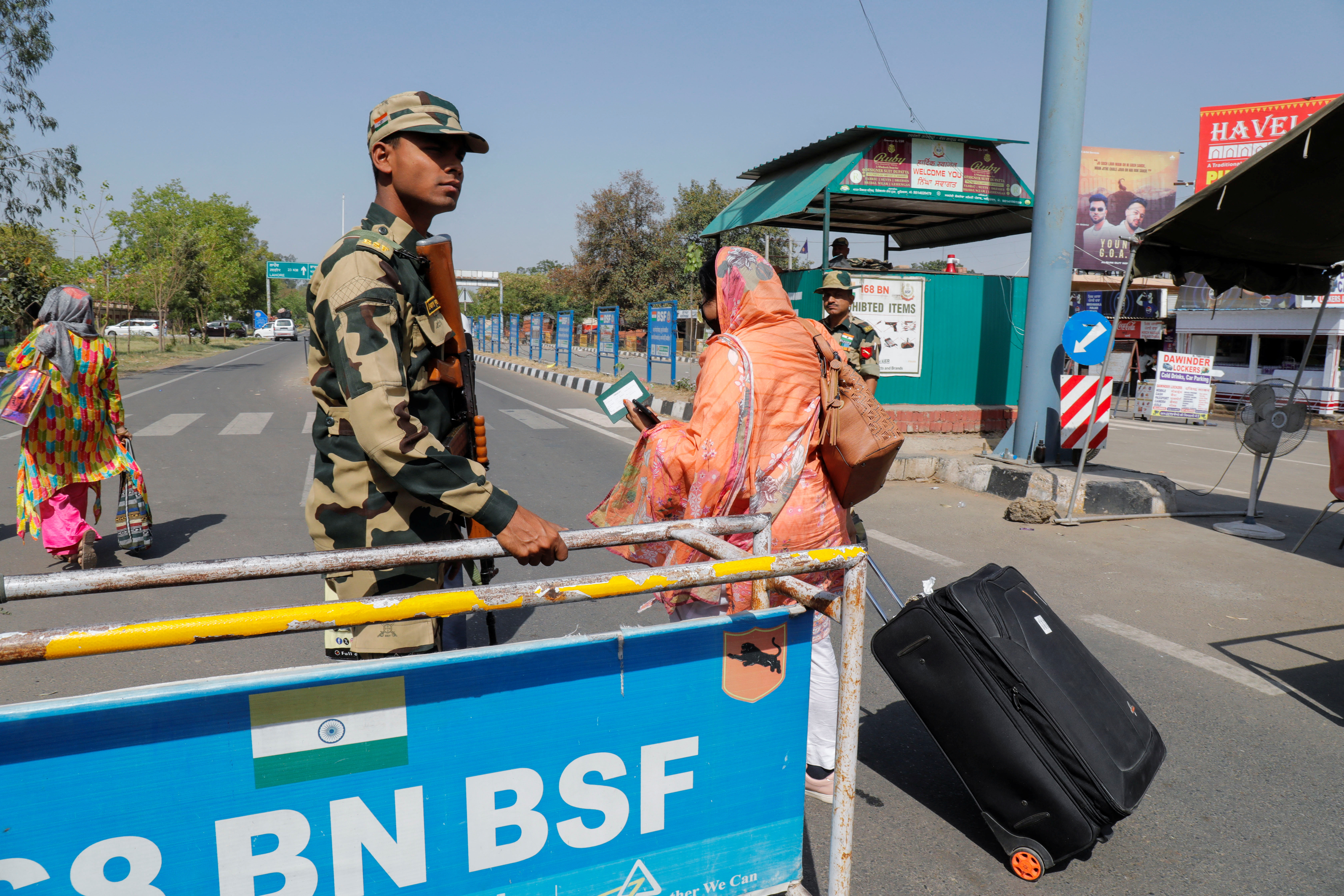 People carry baggage as they cross a border security checkpoint at the Attari-Wagah border crossing.
