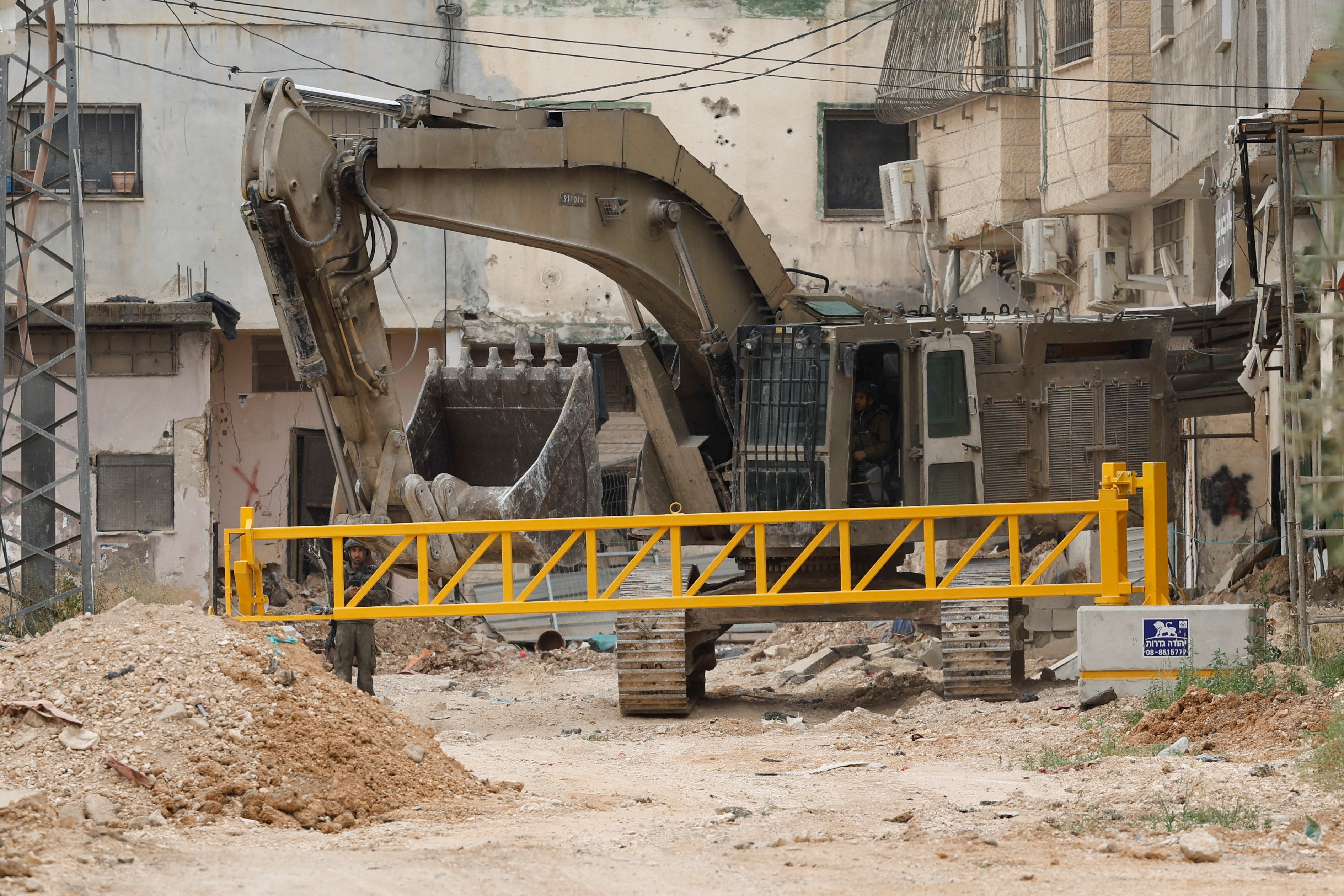 Israeli soldiers install an iron gate at the entrance to Jenin camp, during a military operation that has been ongoing since January 2025, in the Israeli-occupied West Bank, April 23, 2025 REUTERS/Raneen Sawafta