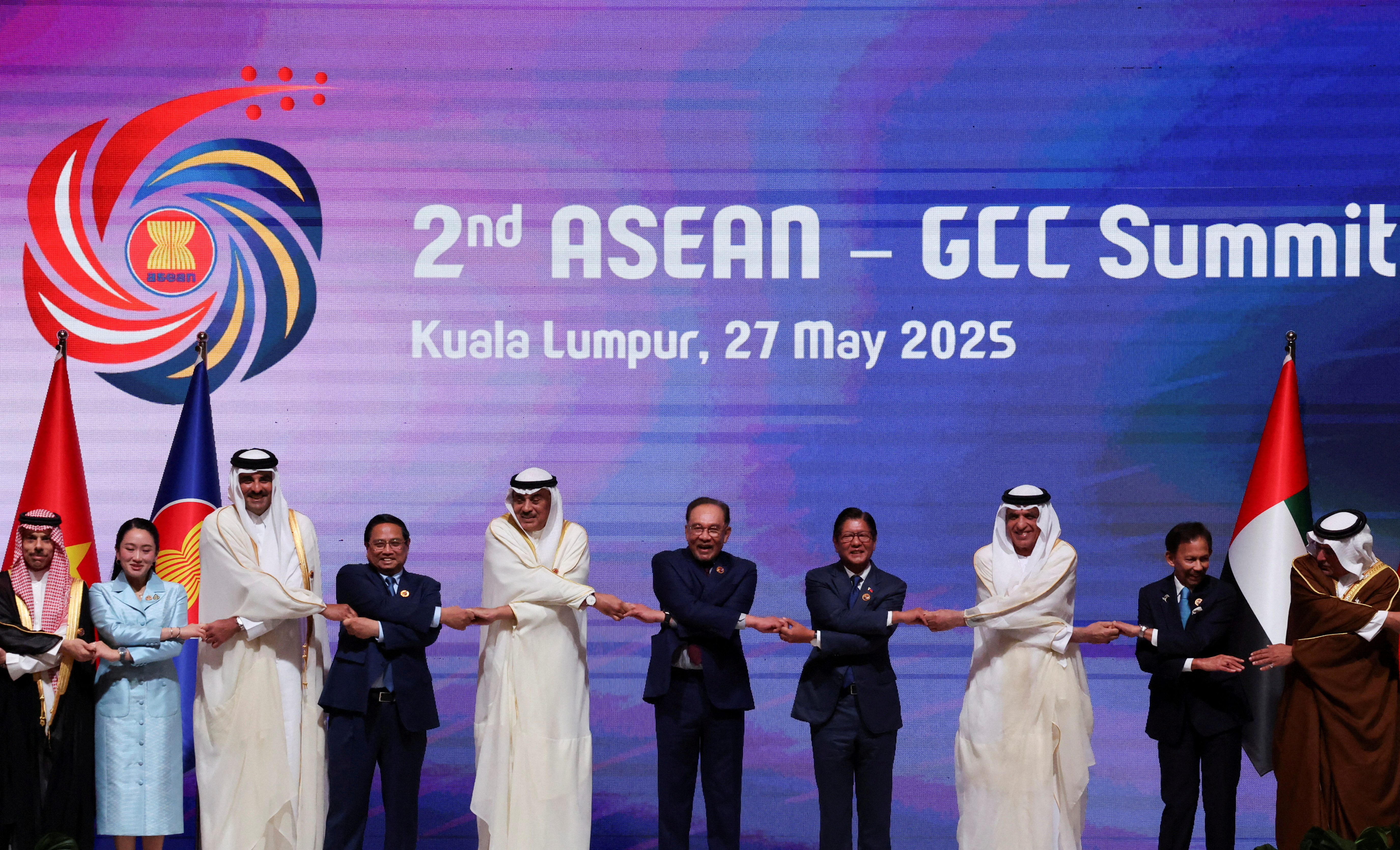 Secretary General of the Gulf Cooperation Council (GCC) Jasem Albudaiwi, Myanmar's Permanent Secretary of the Ministry of Foreign Affairs Aung Kyaw Moe, Laos' Prime Minister Sonexay Siphandone, Singapore's Prime Minister Lawrence Wong, Saudi Arabian Foreign Minister Faisal bin Farhan Al Saud, Thailand's Prime Minister Paetongtarn Shinawatra, Qatar's Emir Tamim bin Hamad Al Thani, Vietnam's Prime Minister Pham Minh Chinh, Kuwait's Crown Prince Sheikh Sabah Khaled Al-Hamad Al-Sabah, Malaysia's Prime Minister Anwar Ibrahim, Philippines' President Ferdinand Marcos Jr, UAE Supreme Council Member and Ruler of Ras Al Khaimah, Sheikh Saud bin Saqr Al Qasimi, Brunei's Sultan Hassanal Bolkiah, Bahrain's Crown Prince Salman bin Hamad Al Khalifa join hands for a group photo as they attend the 2nd ASEAN-GCC Summit at the Kuala Lumpur Convention Centre in Kuala Lumpur, Malaysia, May 27, 2025. REUTERS/Hasnoor Hussain
