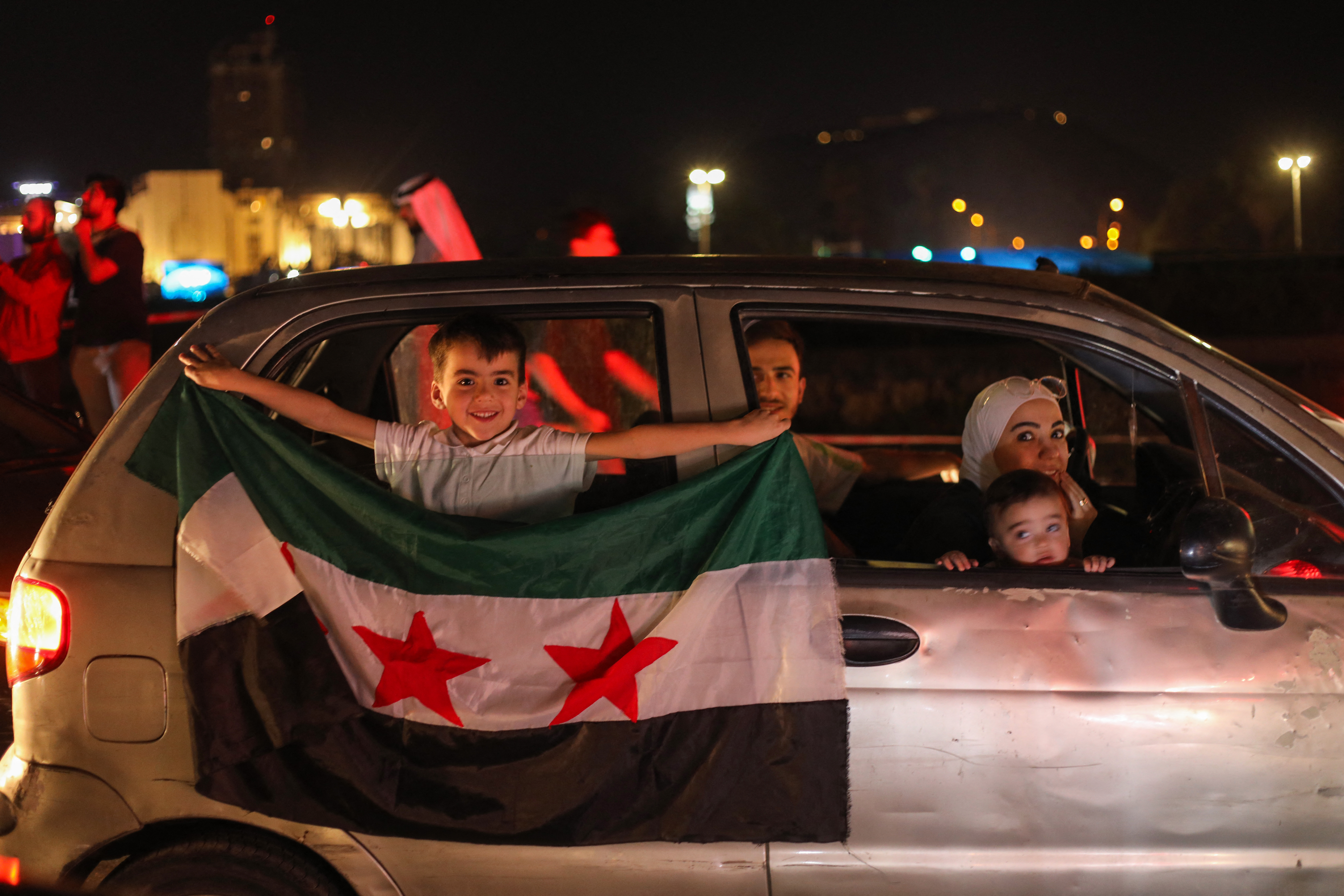 People celebrate in Damascus' Omeyyad square after US President Donald Trump's decision to lift sanctions in Syria, on May 13, 2025. (Photo by Abdulaziz KETAZ / AFP)