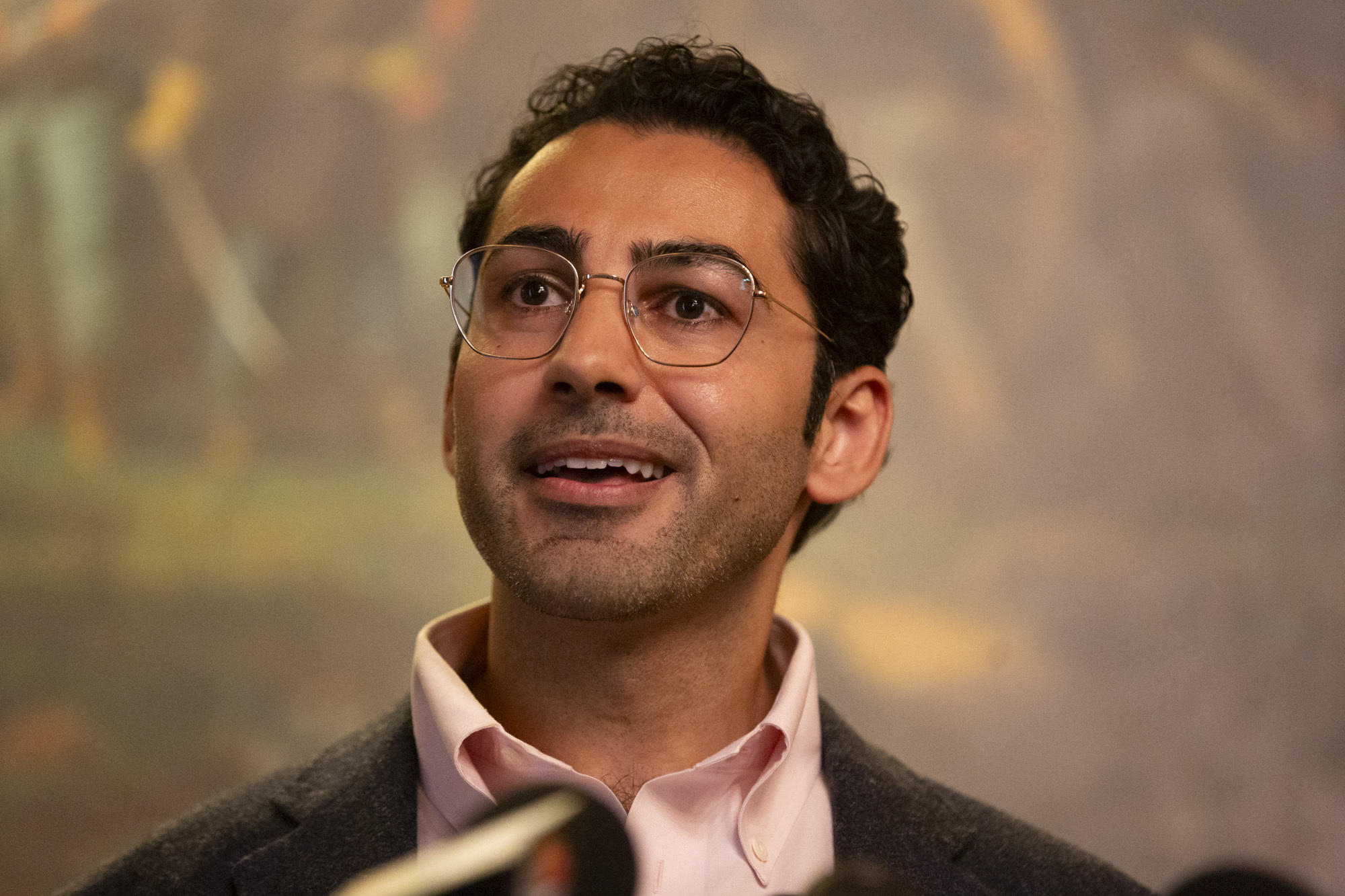 Mohsen Mahdawi in close-up as he speaks into a microphone.