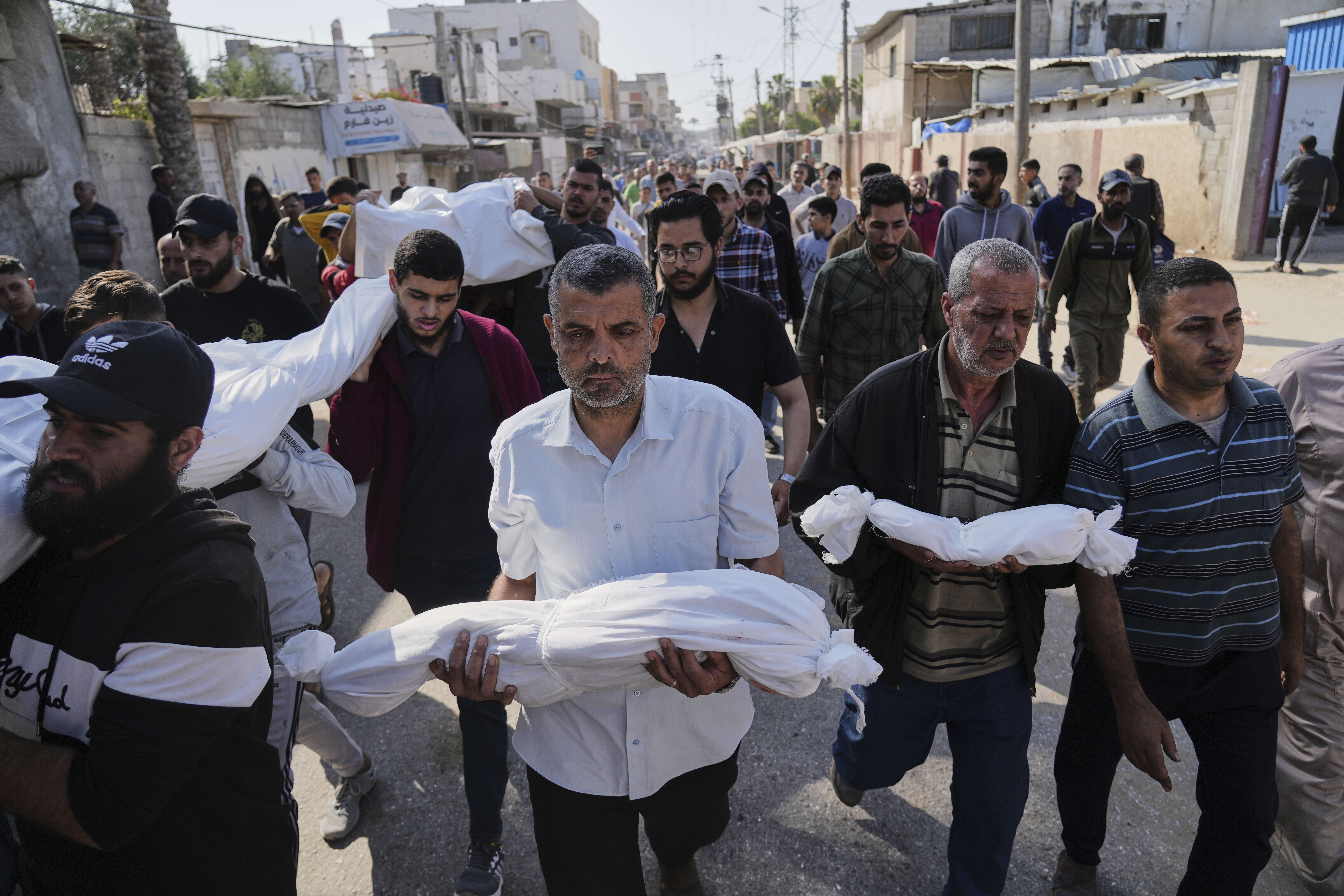 Palestinian carry the bodies of their relatives including children who were killed in an Israeli army airstrike in Deir al-Balah, Gaza