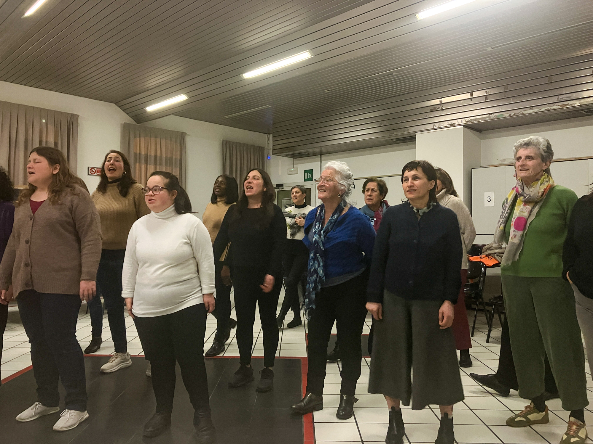 Choir members are coached in an improvisational harmonising exercise during rehearsal. [Michela Moscufo/Al Jazeera]