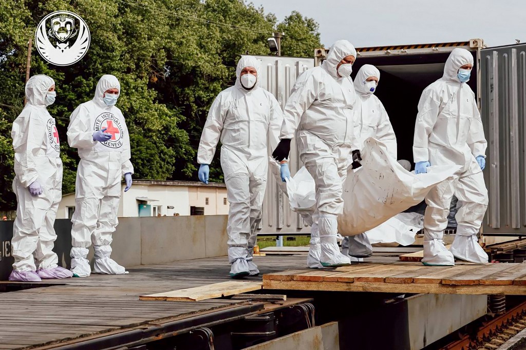 Employees of the International Committee of the Red Cross unload what are reported to be the bodies of Ukrainian citizens, including military personnel, returned by Russia, from a refrigerator carriage at an undisclosed location in Ukraine [File: AFP]