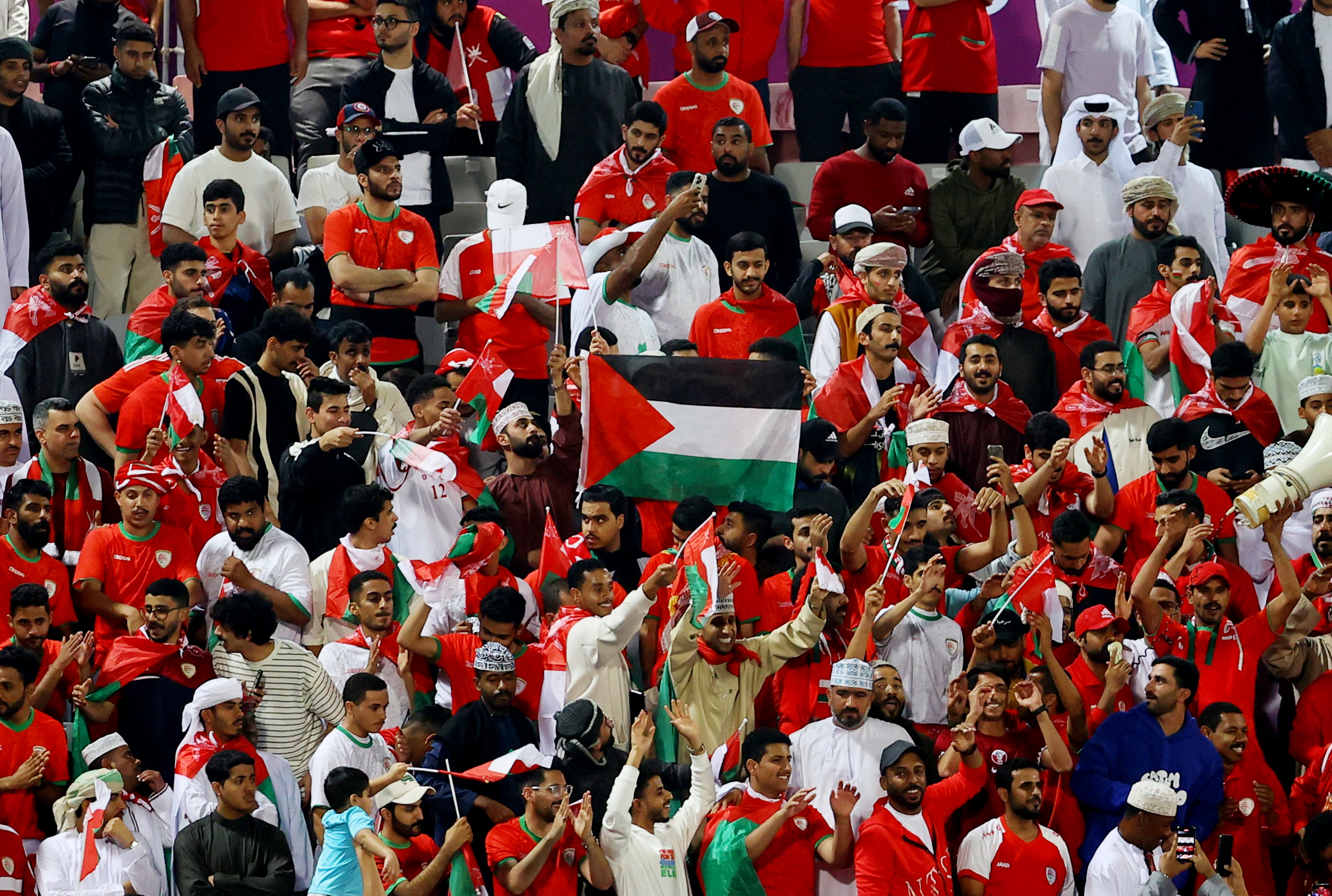 Soccer Football - AFC Asian Cup - Group F - Kyrgyzstan v Oman - Abdullah bin Khalifa Stadium, Doha, Qatar - January 25, 2024 Oman fans display a flag in support of Palestine amid the ongoing conflict between Israel and Hamas REUTERS/Ibraheem Al Omari