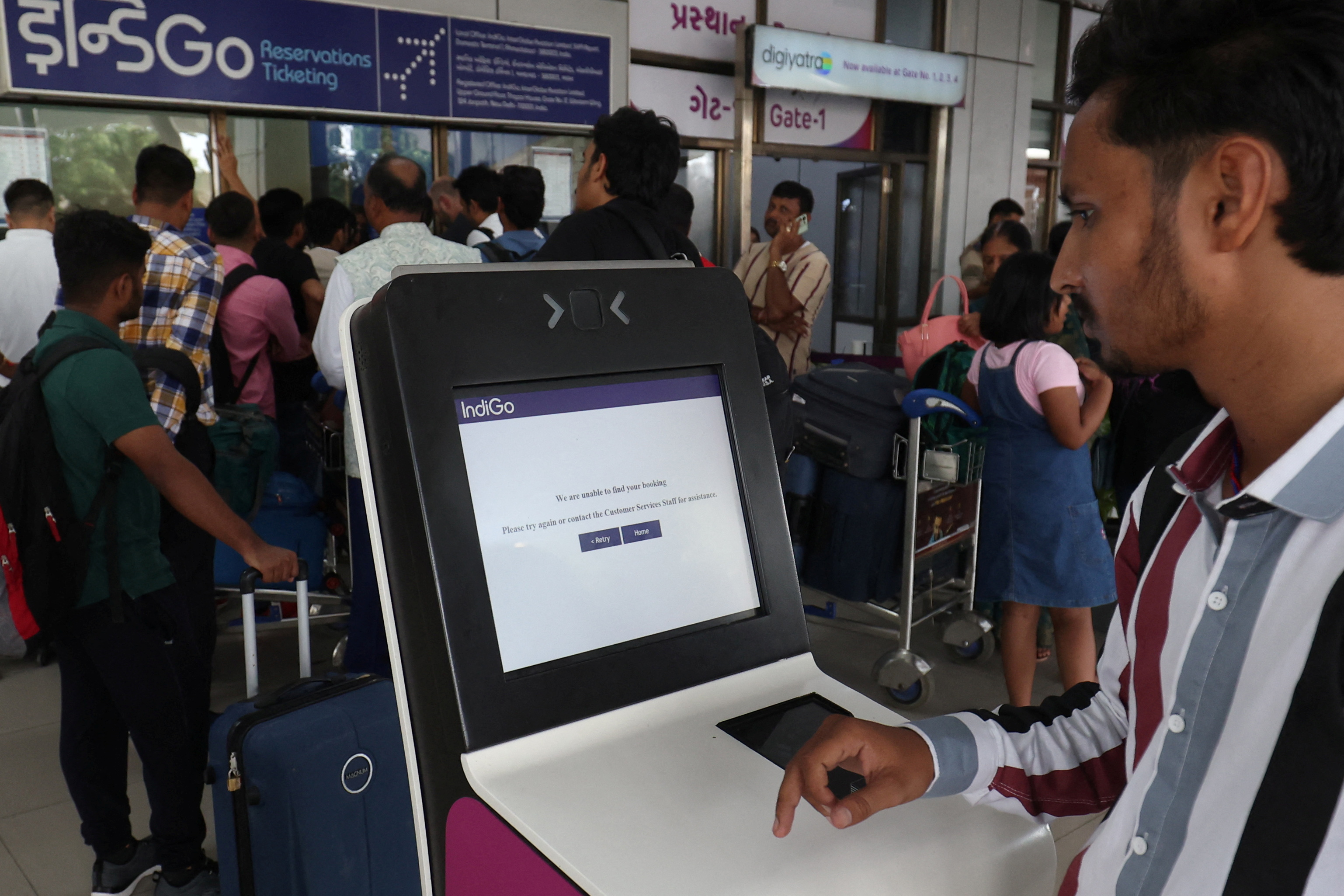 A passenger reads a message on a self check-in machine at Ahmedabad airport in India