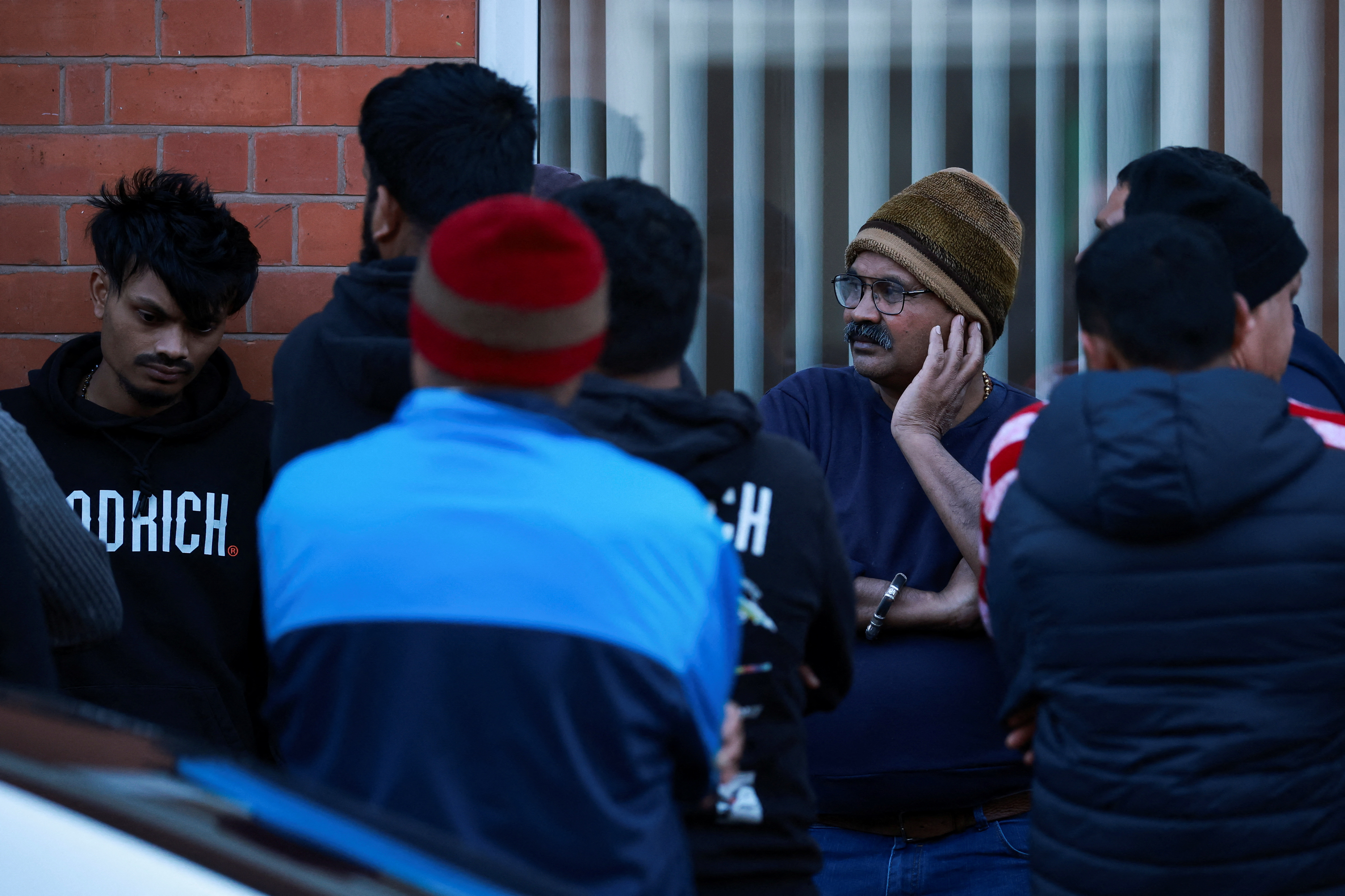 Members of the local community in Leicester, UK, stand outside a home amid news of a deadly Air India crash