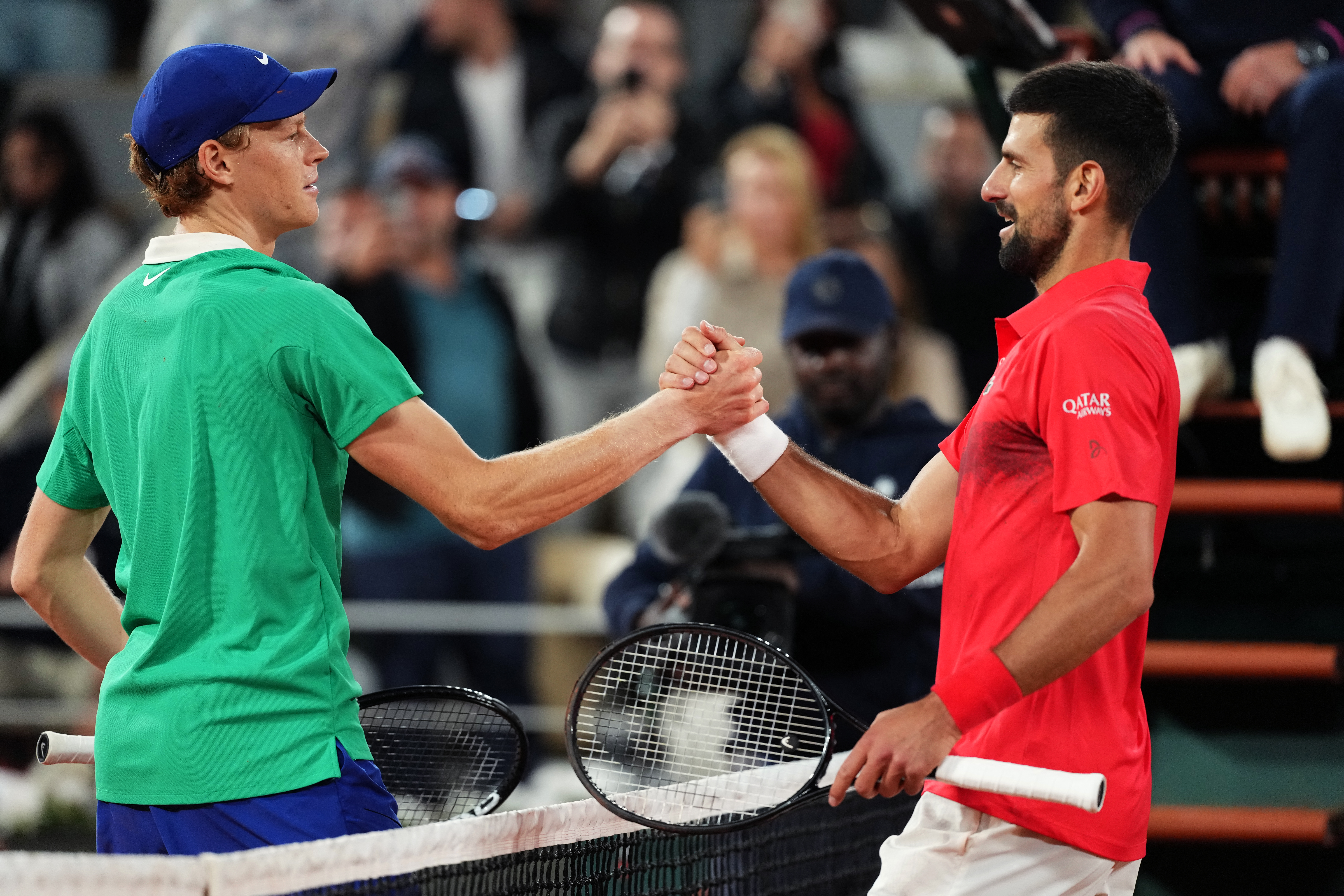 Italy's Jannik Sinner (L) shakes hands with Serbia's Novak Djokovic after winning their men's singles semi-final match on day 13 of the French Open tennis tournament on Court Philippe-Chatrier at the Roland-Garros