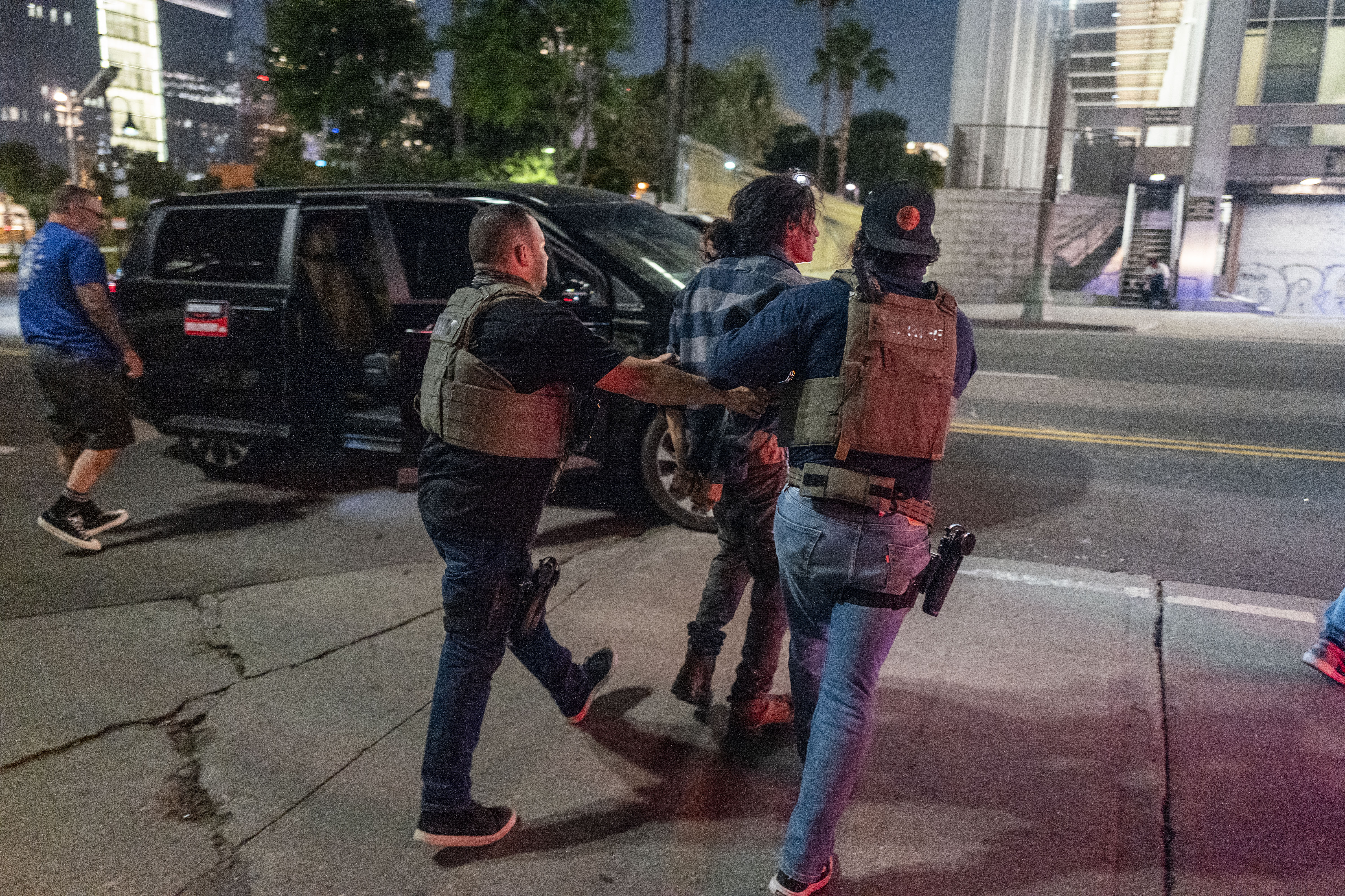 Law enforcement officers arrest a man as a curfew is in effect following days of protests in Los Angeles