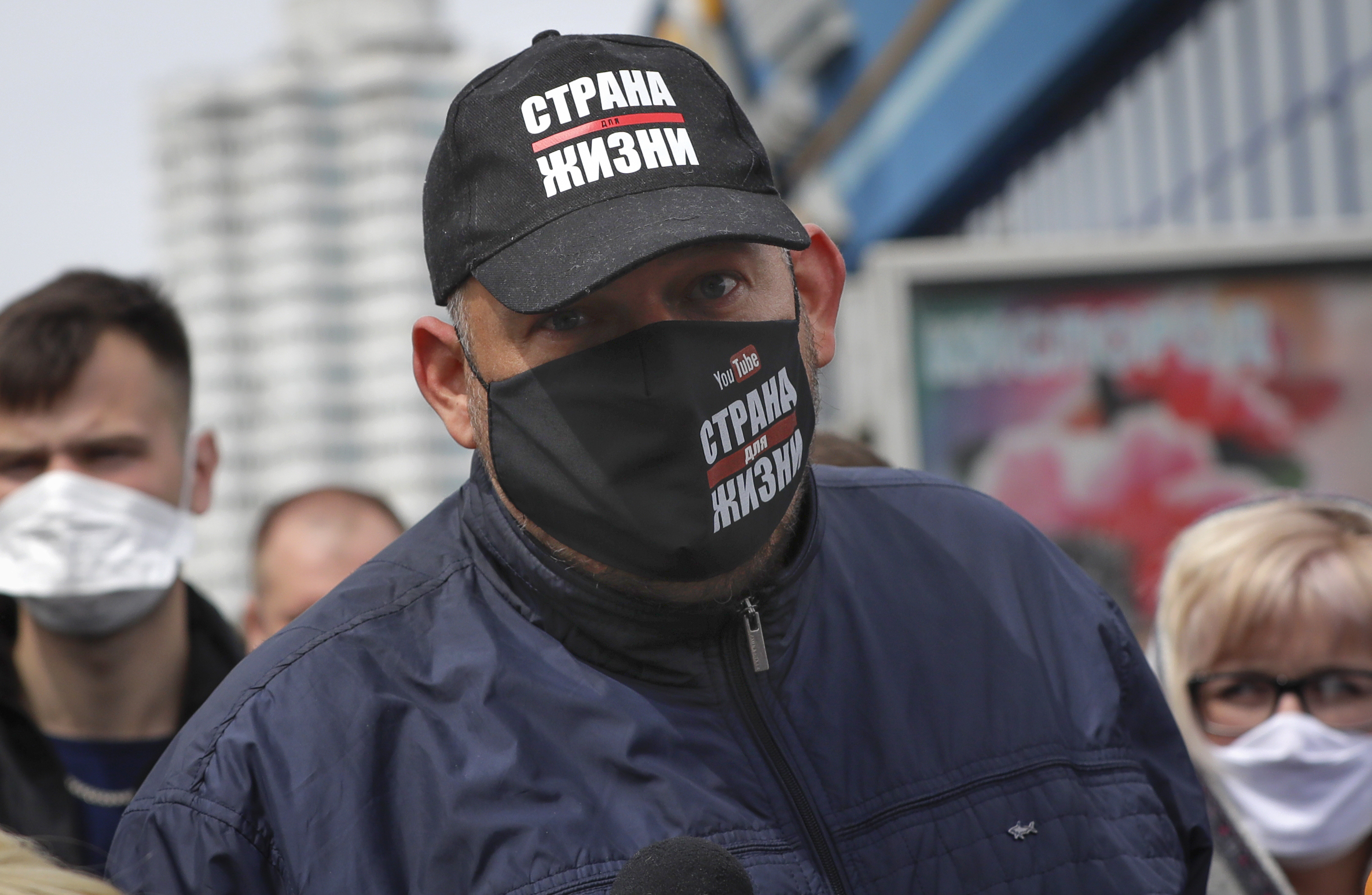 Blogger Siarhei Tsikhanouski, wearing a face mask to protect against coronavirus, speaks to people gathered to sign up and support potential presidential candidates in the upcoming presidential elections in Minsk, Belarus, Sunday, May 24, 2020. A court in Belarus on Tuesday, Dec. 14, 2021 sentenced the husband of the country's opposition leader to 18 years in prison, six months after the trial began behind closed doors. The charges against Siarhei Tsikhanouski included organizing mass unrest and inciting hatred and have been widely seen as politically motivated. (AP Photo/Sergei Grits, File)