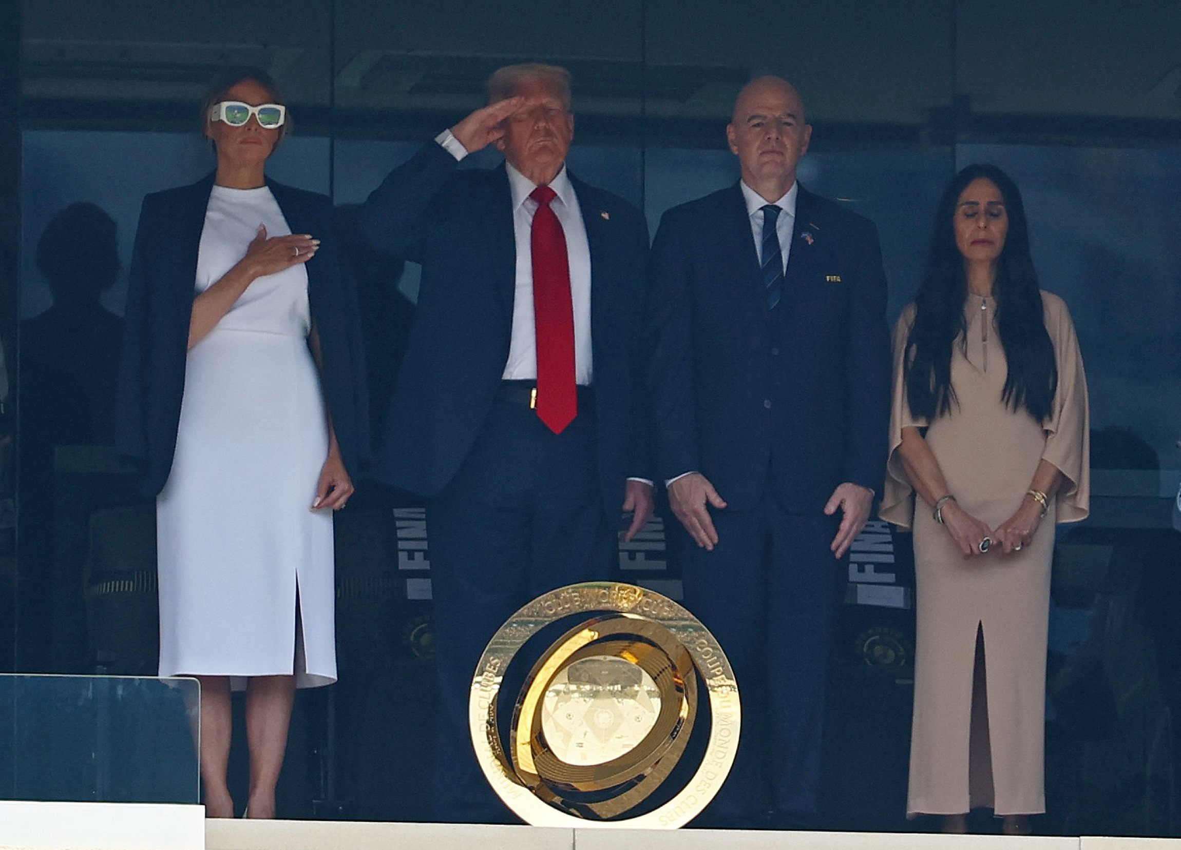 Football - FIFA Club World Cup - Final - Chelsea v Paris St Germain - MetLife Stadium, East Rutherford, New Jersey, U.S. - July 13, 2025 U.S. President Donald Trump salutes alongside first lady Melania Trump