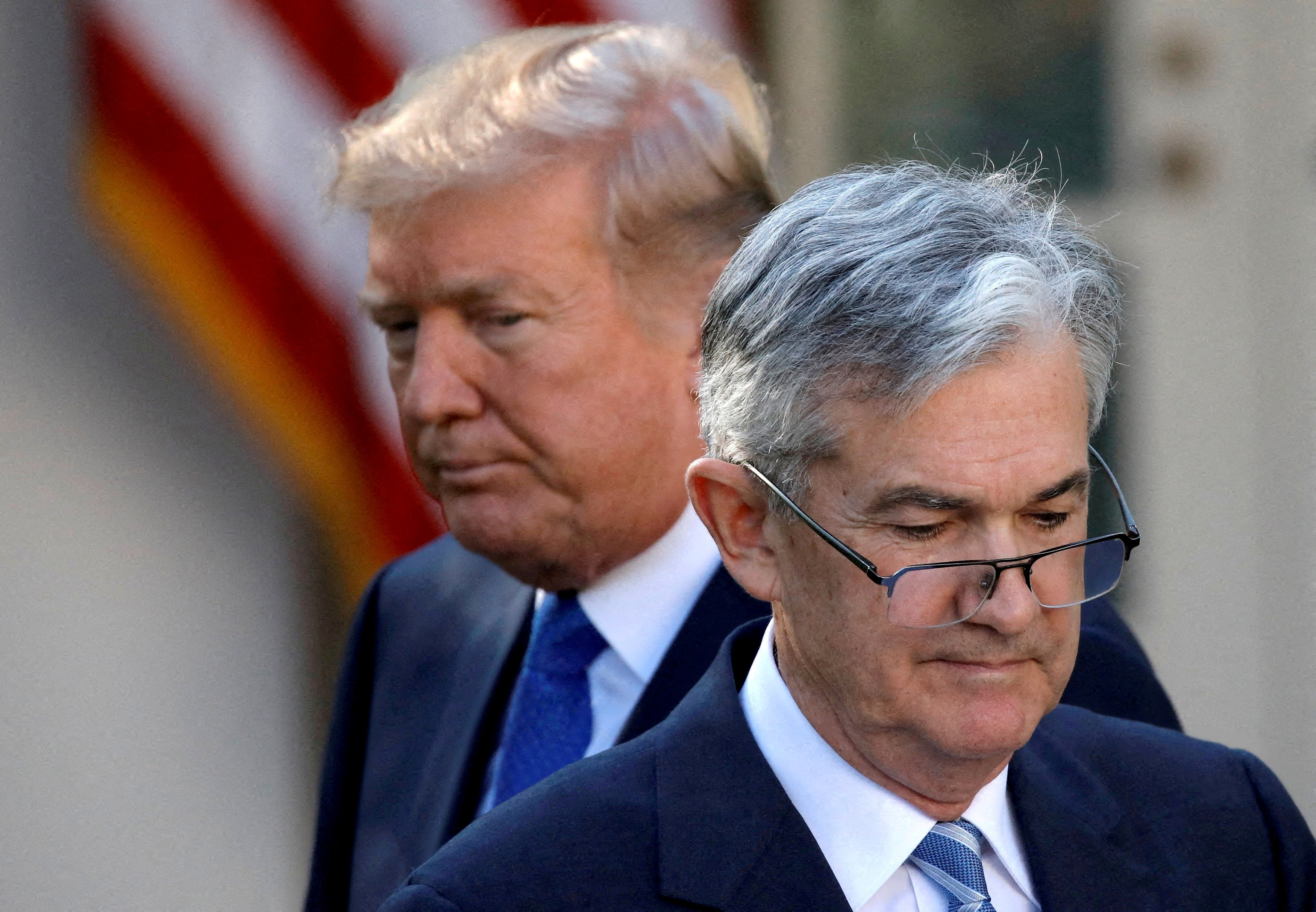 US President Donald Trump looks on as Jerome Powell moves to a podium.