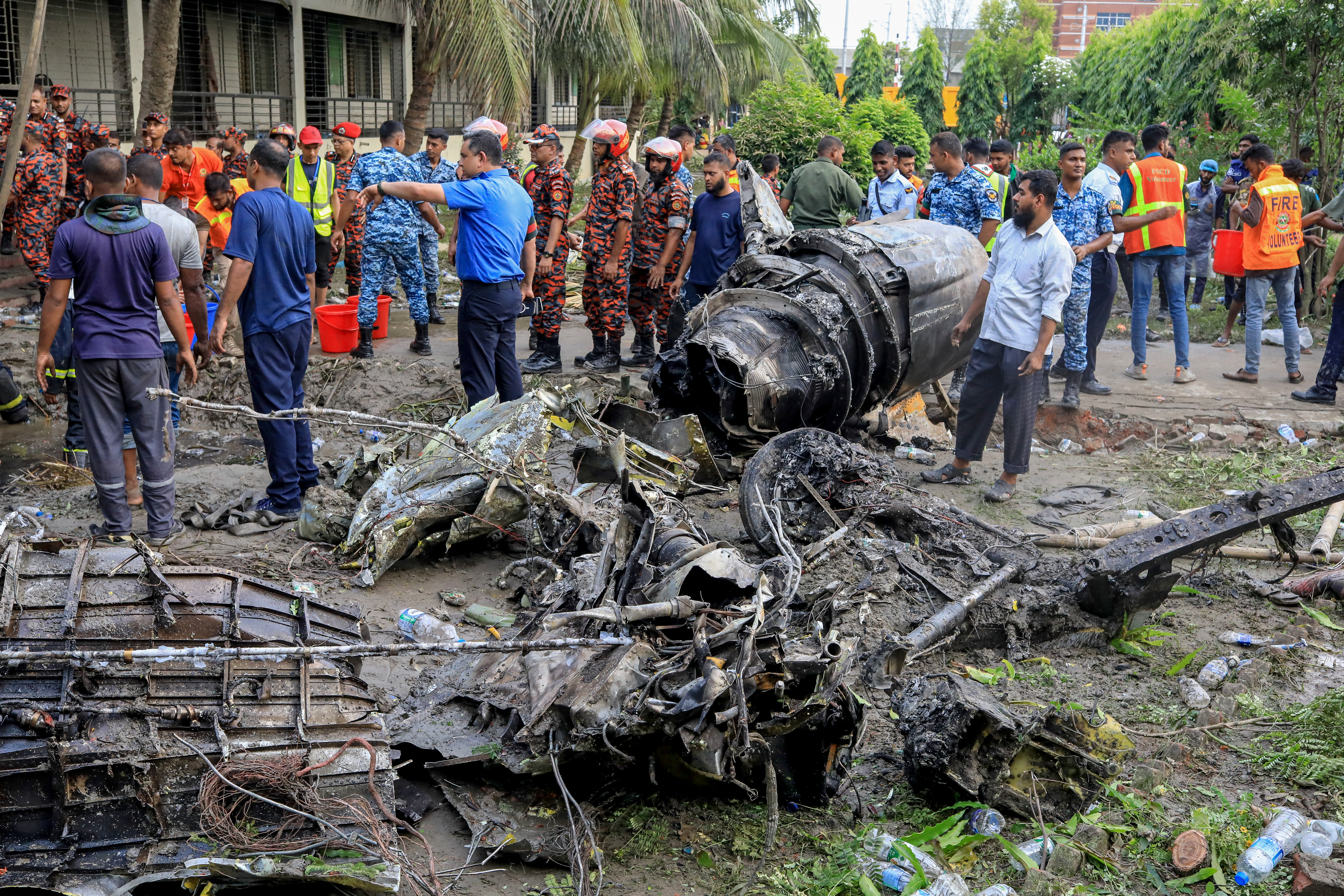 Bangladesh's fire service and security personnel conduct a search and rescue operation after an Air Force training jet crashed into a school in Dhaka