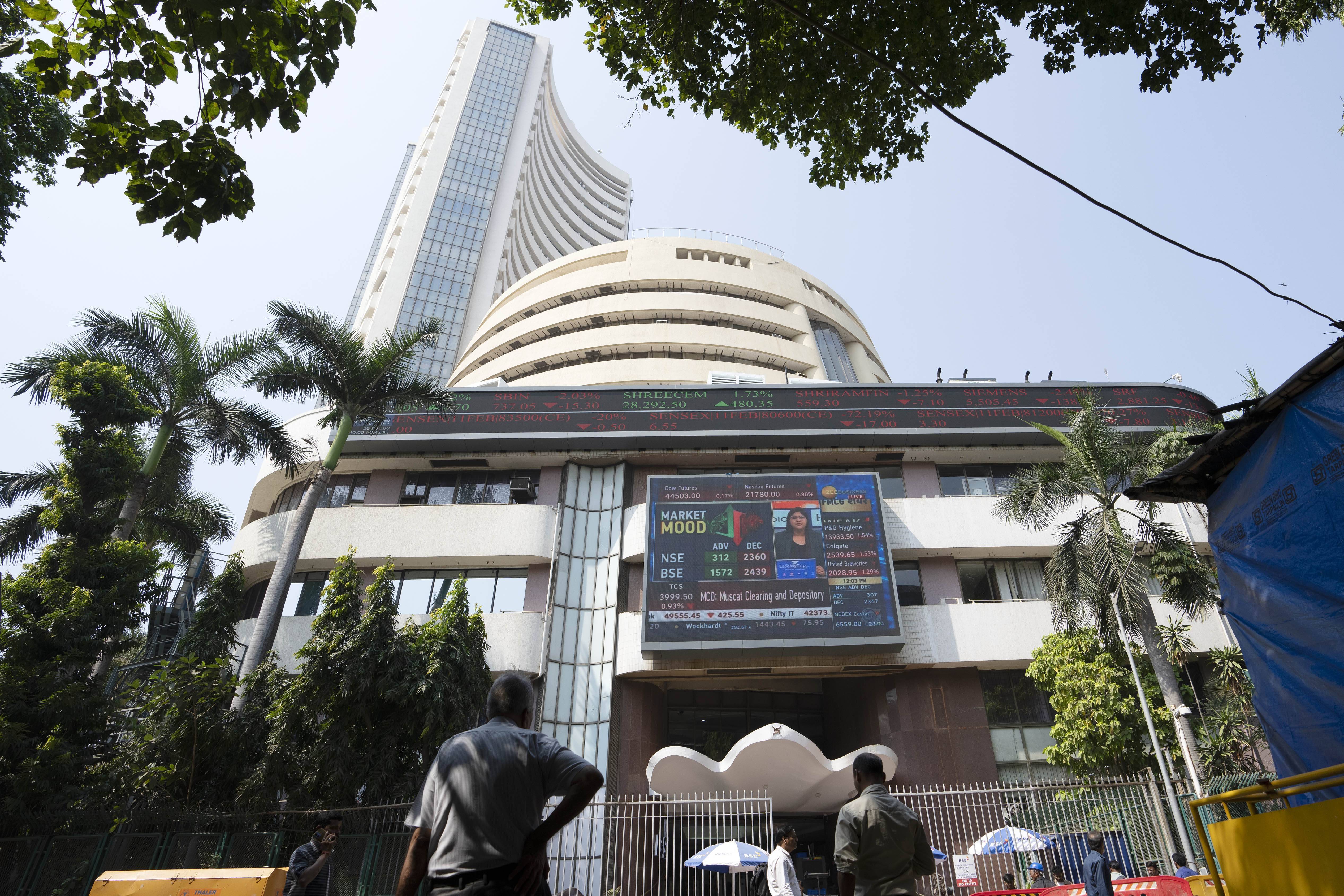 People watch the display screen outside Bombay Stock Market, BSE in Mumbai, India,