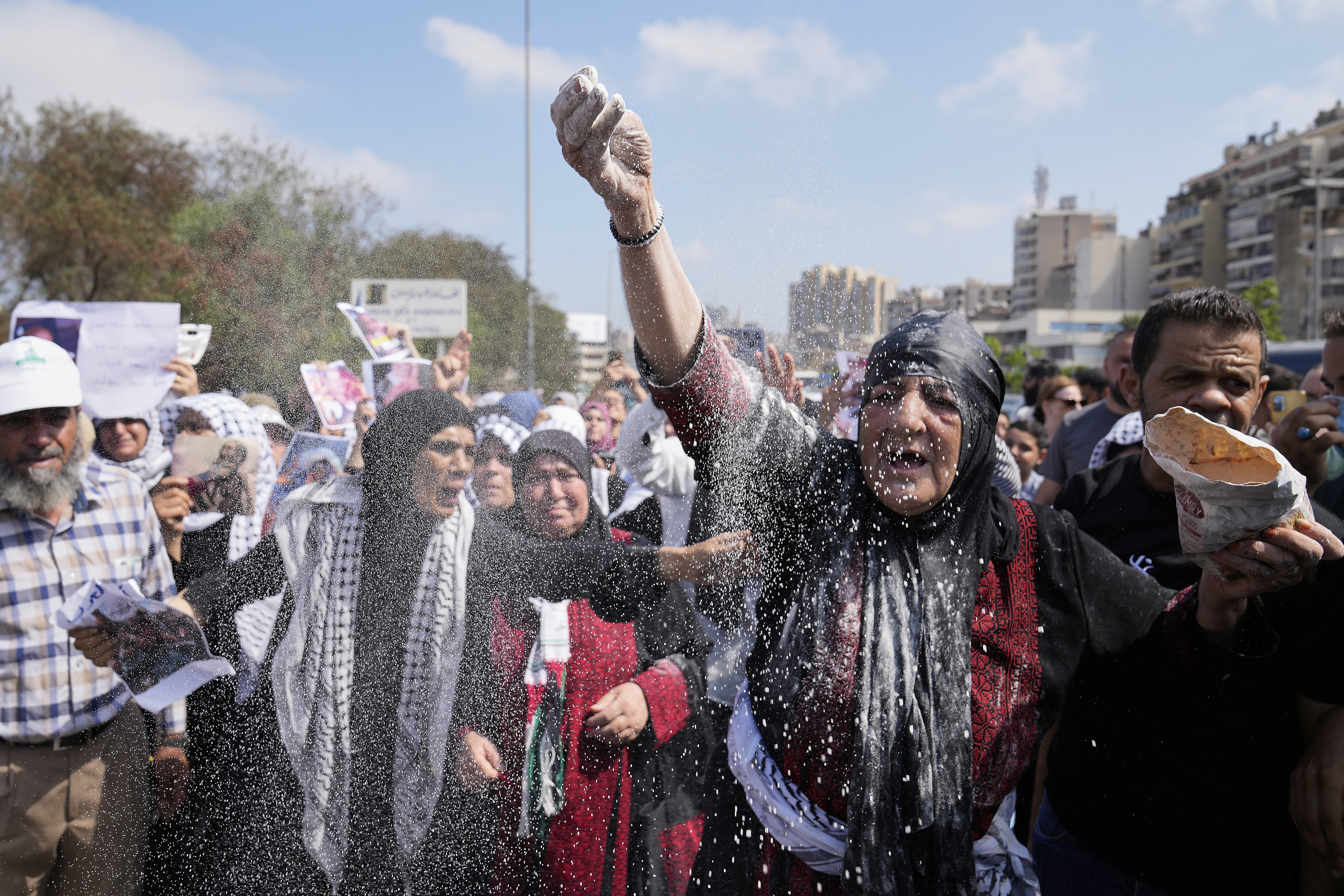A woman throws flour, as she protests outside the Egyptian Embassy in Beirut, Lebanon