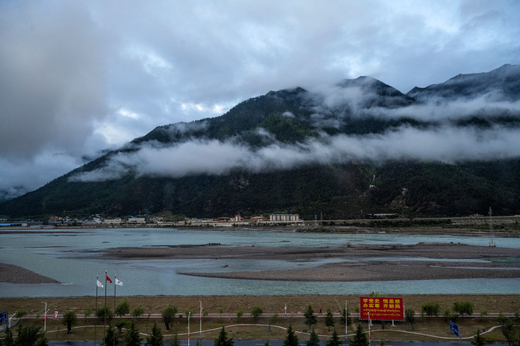 a view of a river with clouds rising above it