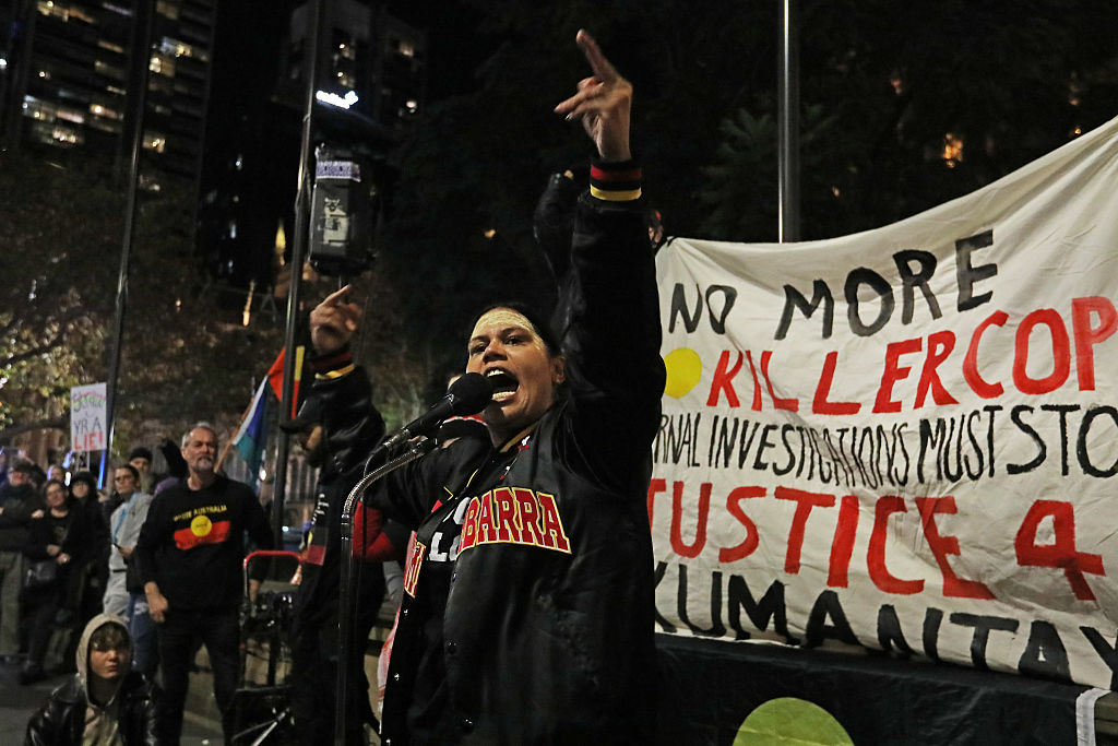 people stand at a protest with a sign that reads no more killer cops