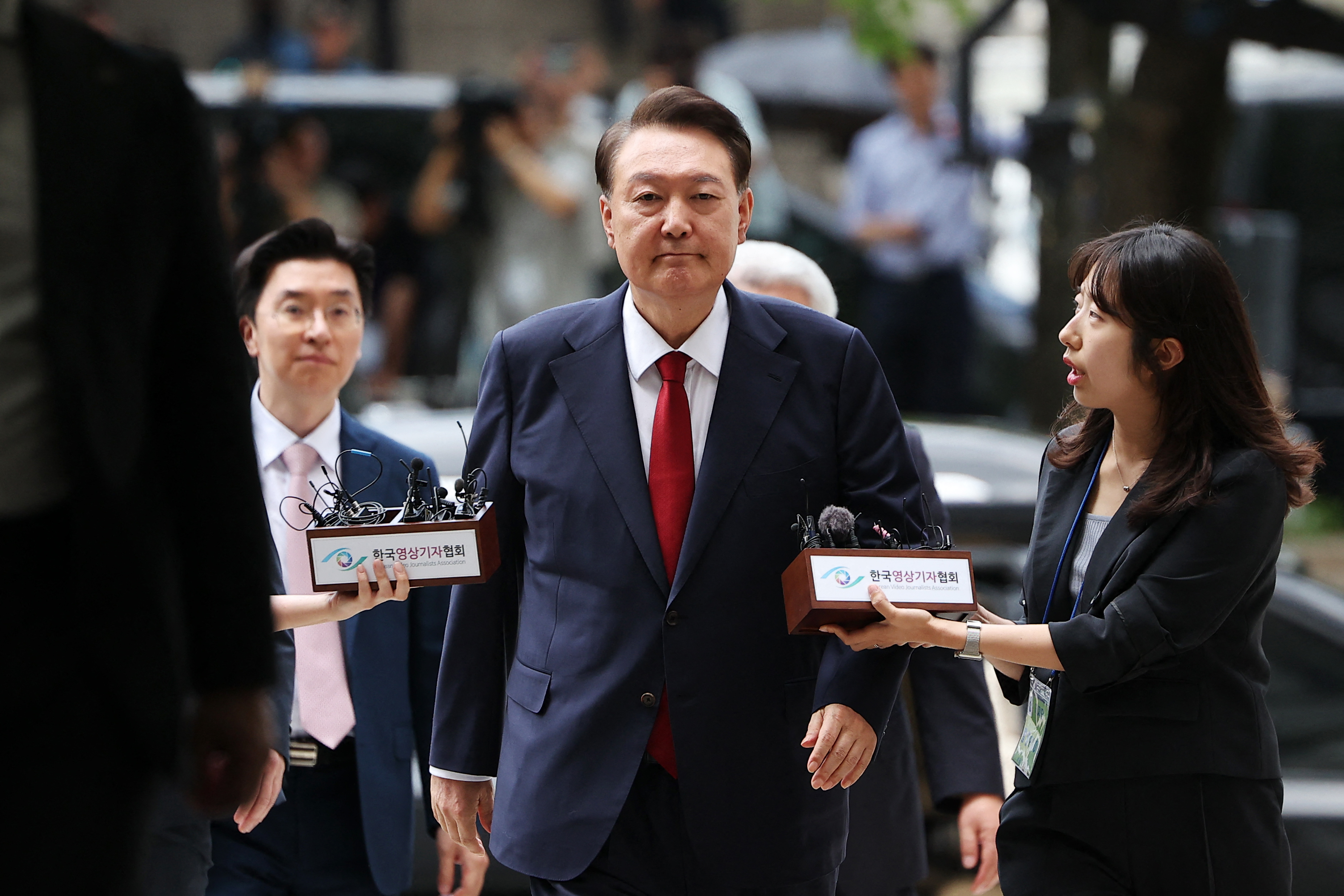 South Korea's former impeached president Yoon Suk Yeol (C) arrives at a court to attend a hearing to review his arrest warrant requested by special prosecutors, in Seoul on July 9, 2025.