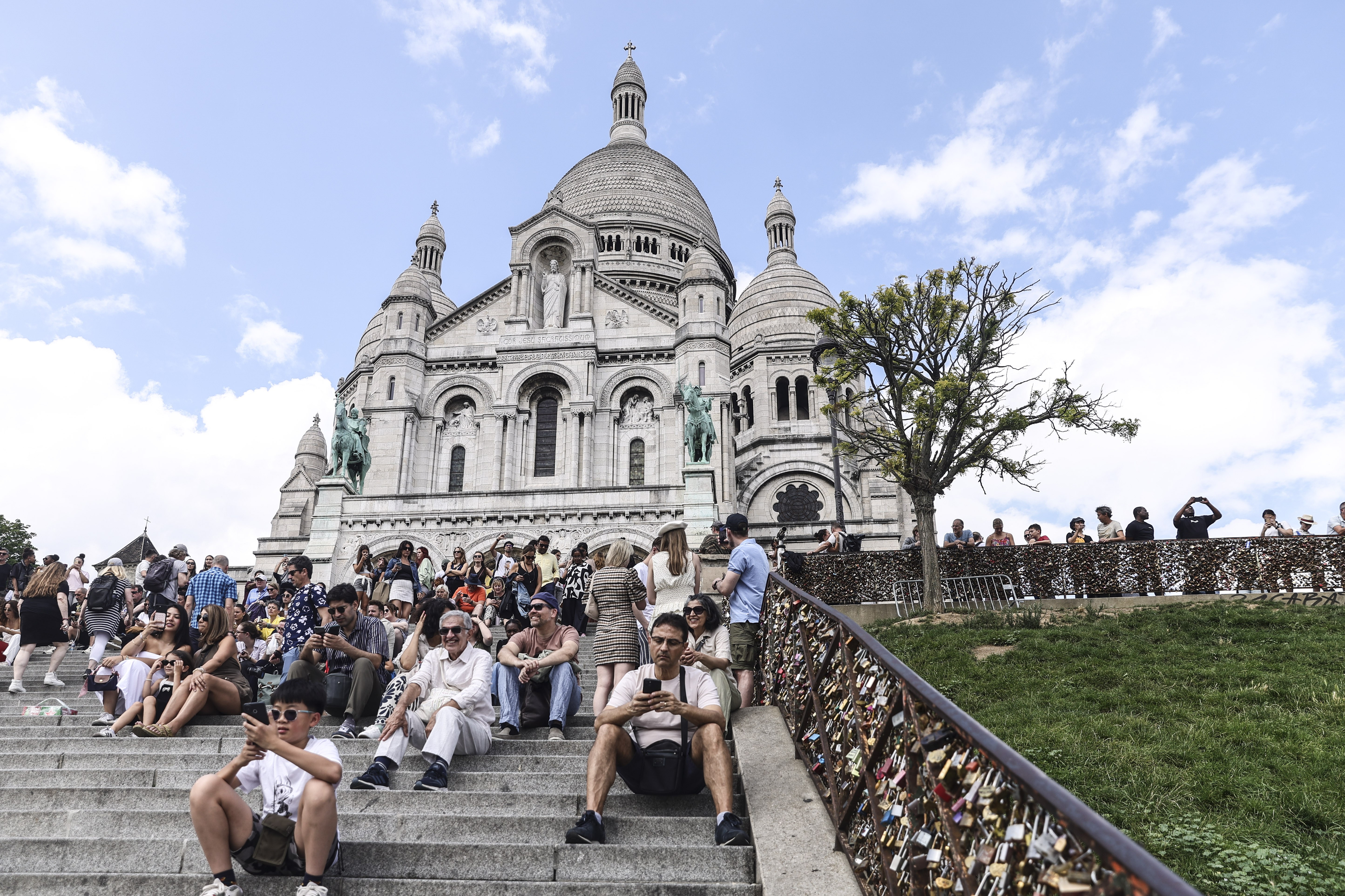 People sit on the steps leading to the Sacre-Cur Basilica, in Montmartre, Paris